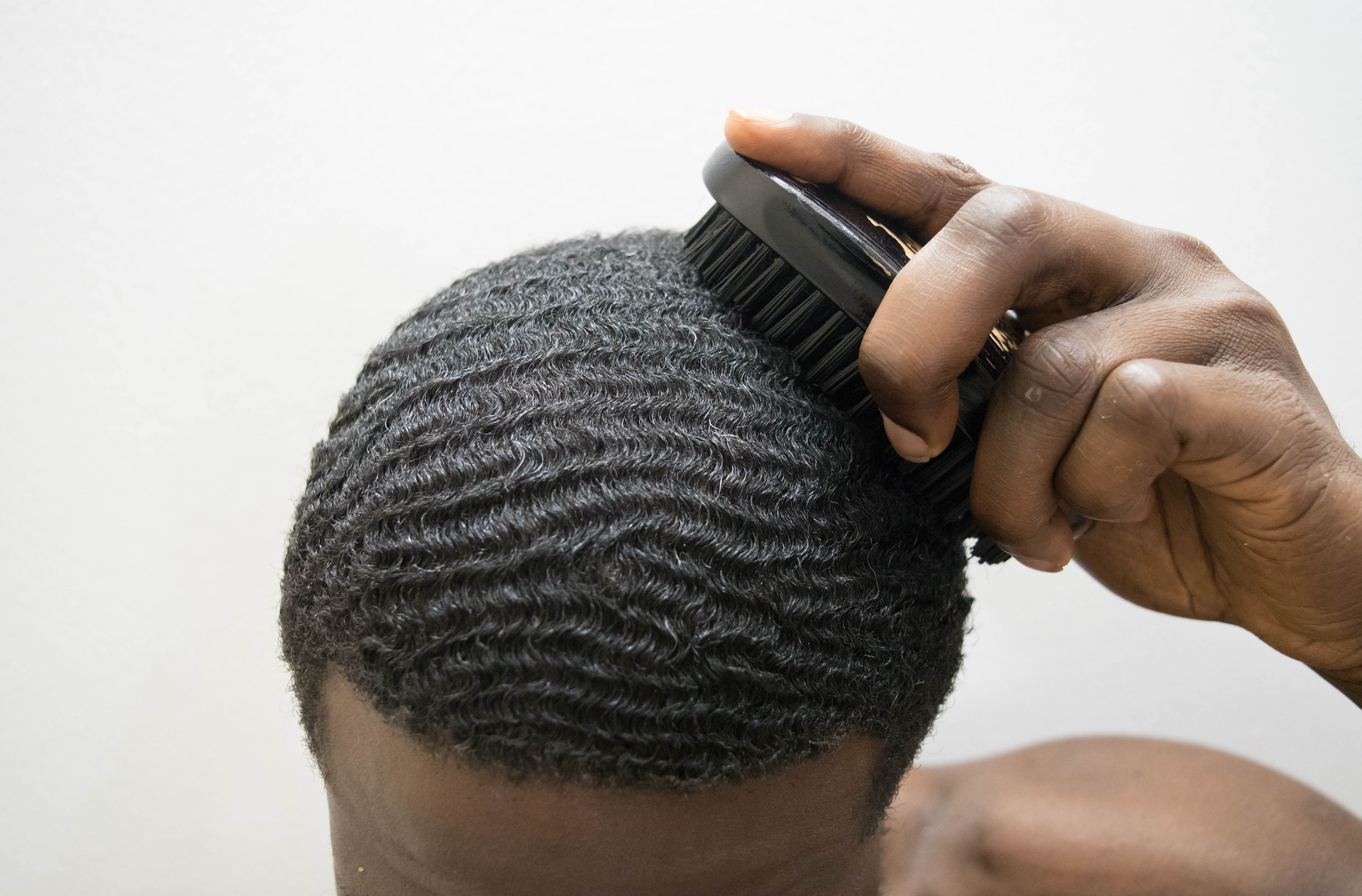 A man is brushing his hair with a brush.