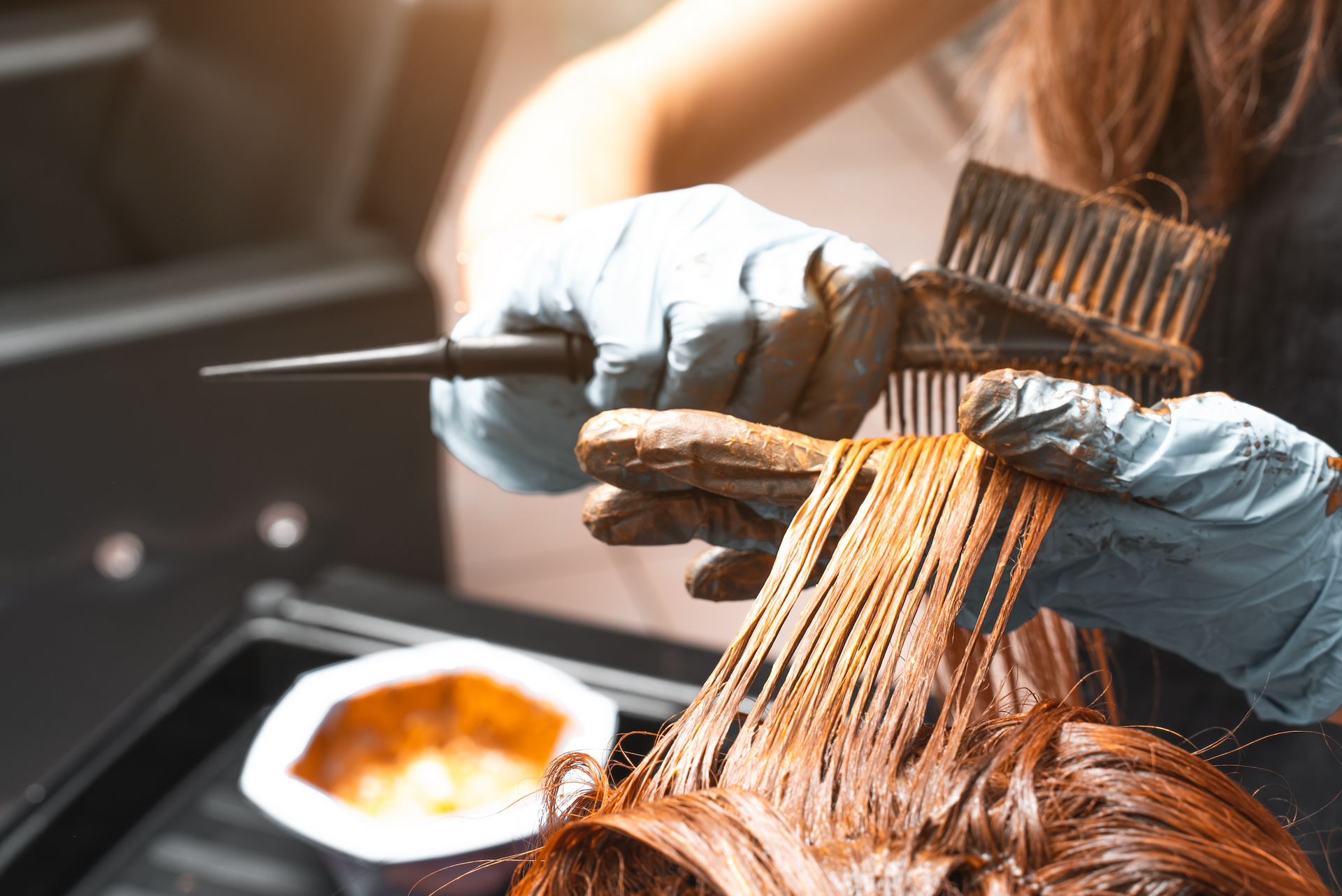 A woman is getting her hair dyed in a salon.