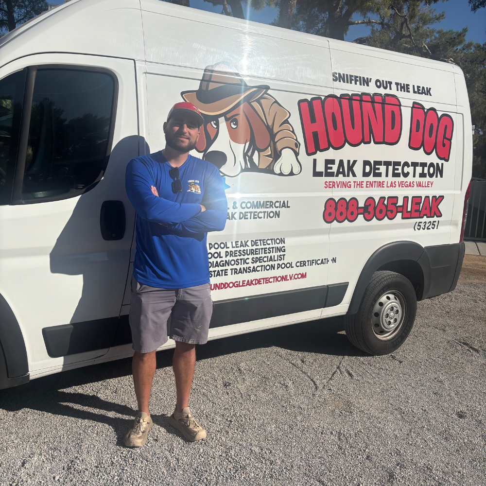 Man standing beside white Hound Dog Leak Detection service van with red logo and phone number