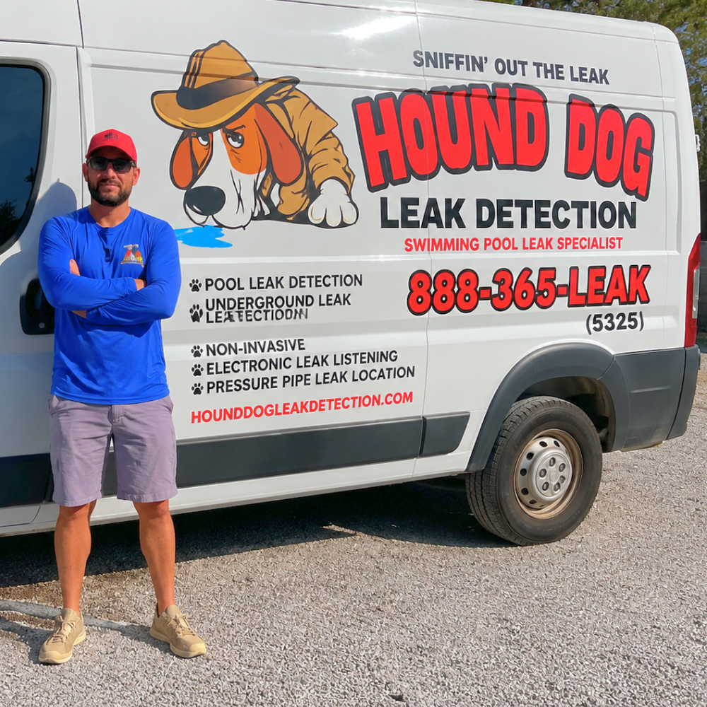 Man standing beside a Hound Dog Leak Detection van with logo and phone number on the side.
