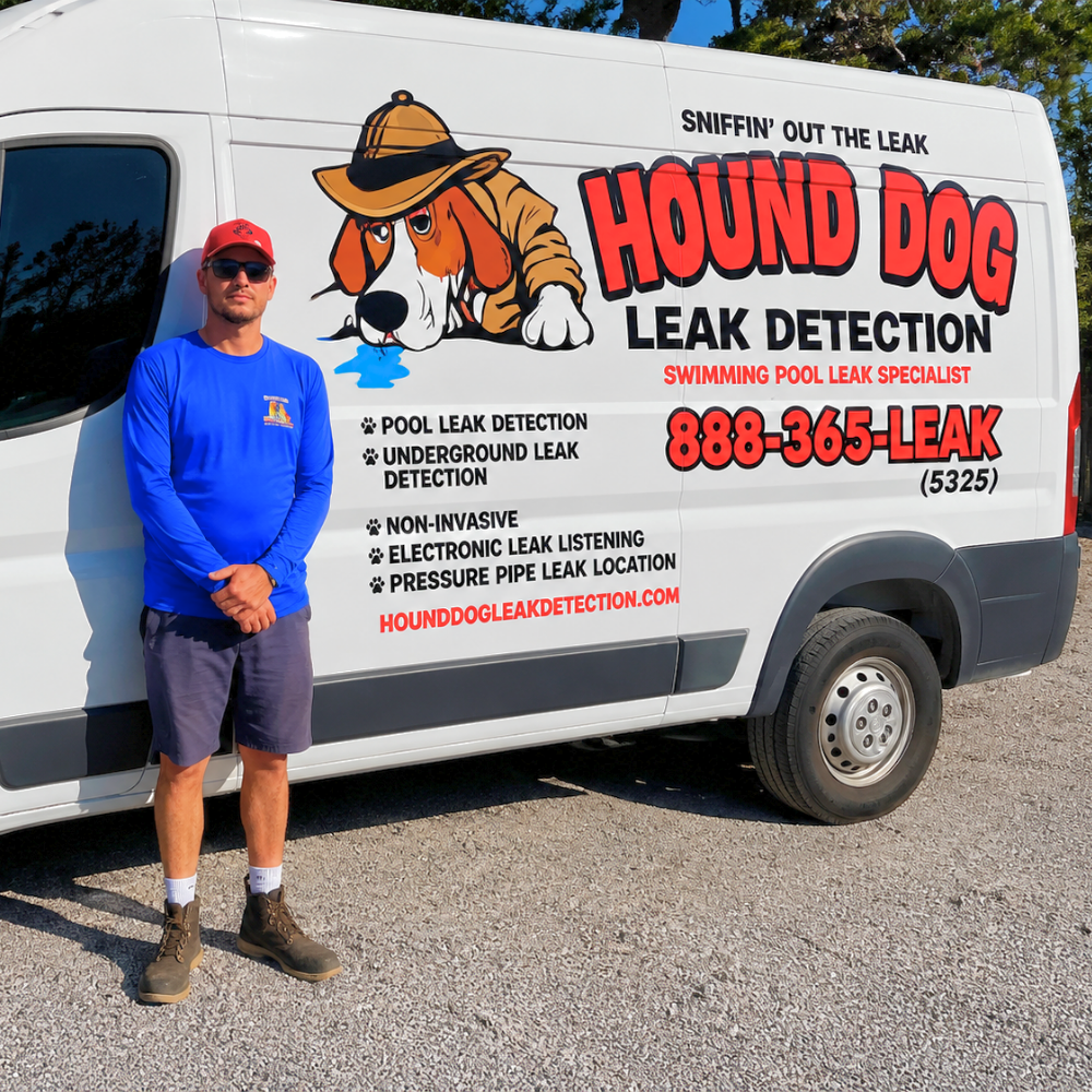 Man standing beside a white leak detection van with bold red Hound Dog logo and contact number