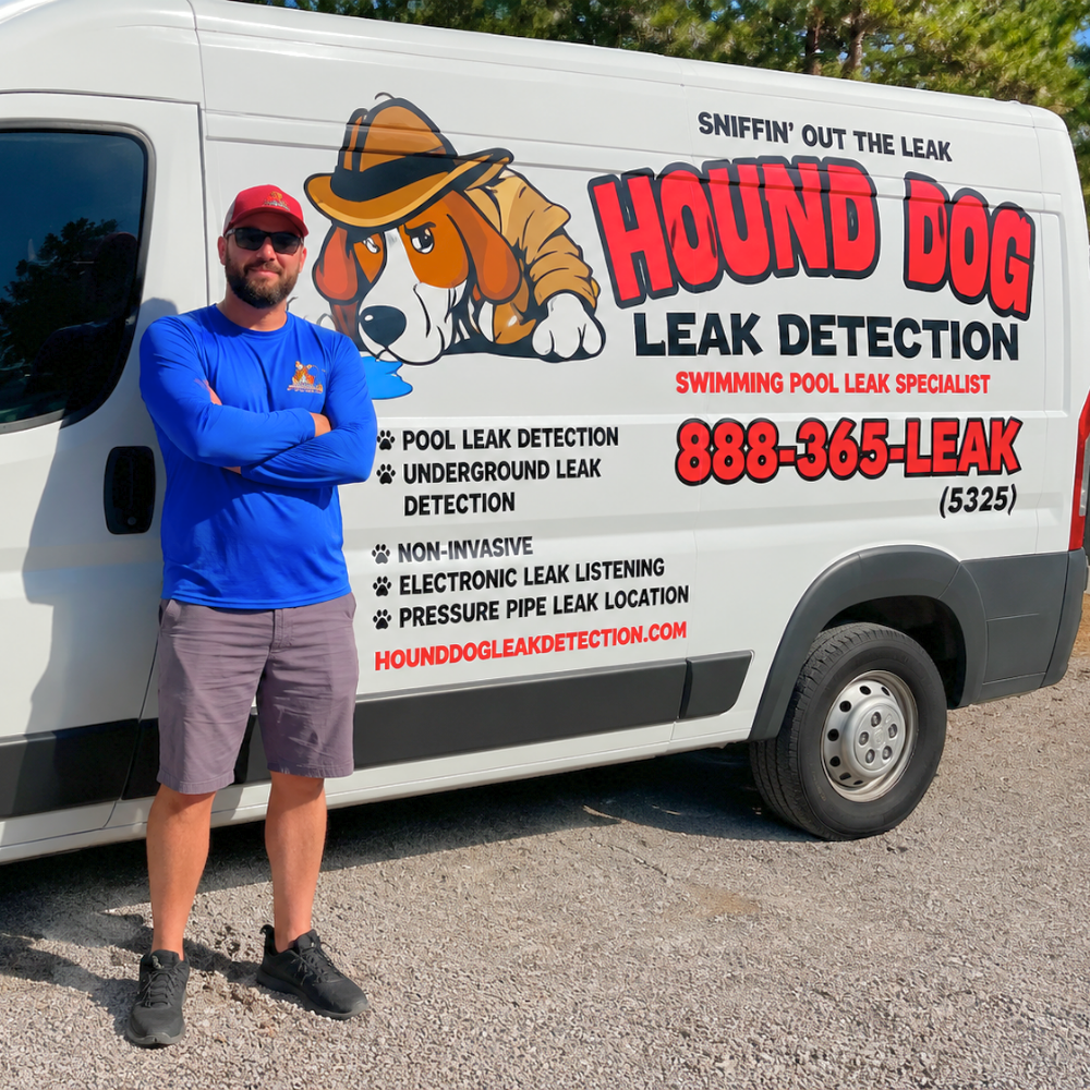 Man standing beside a white Hound Dog Leak Detection van with company logo and phone number printed on the side