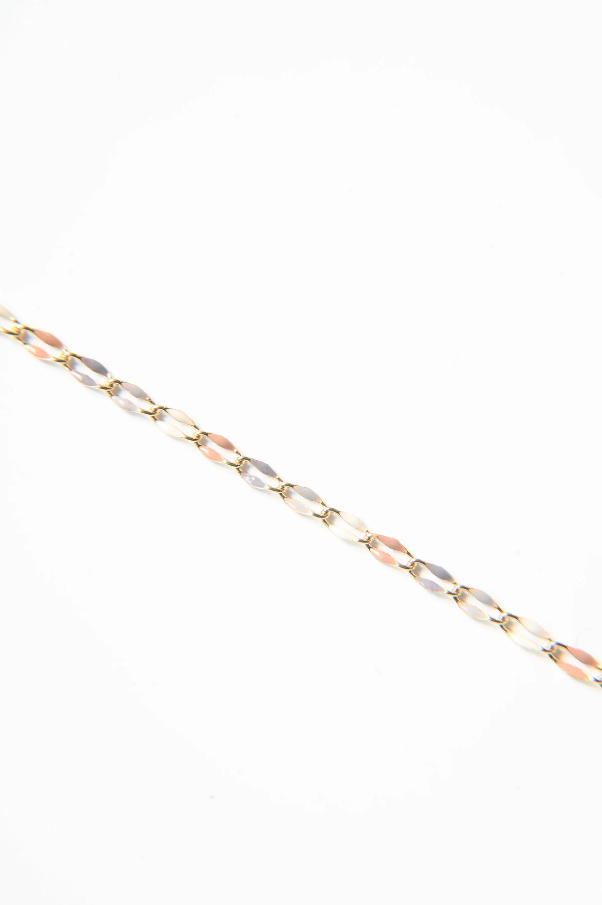 A close up of a gold chain on a white background.