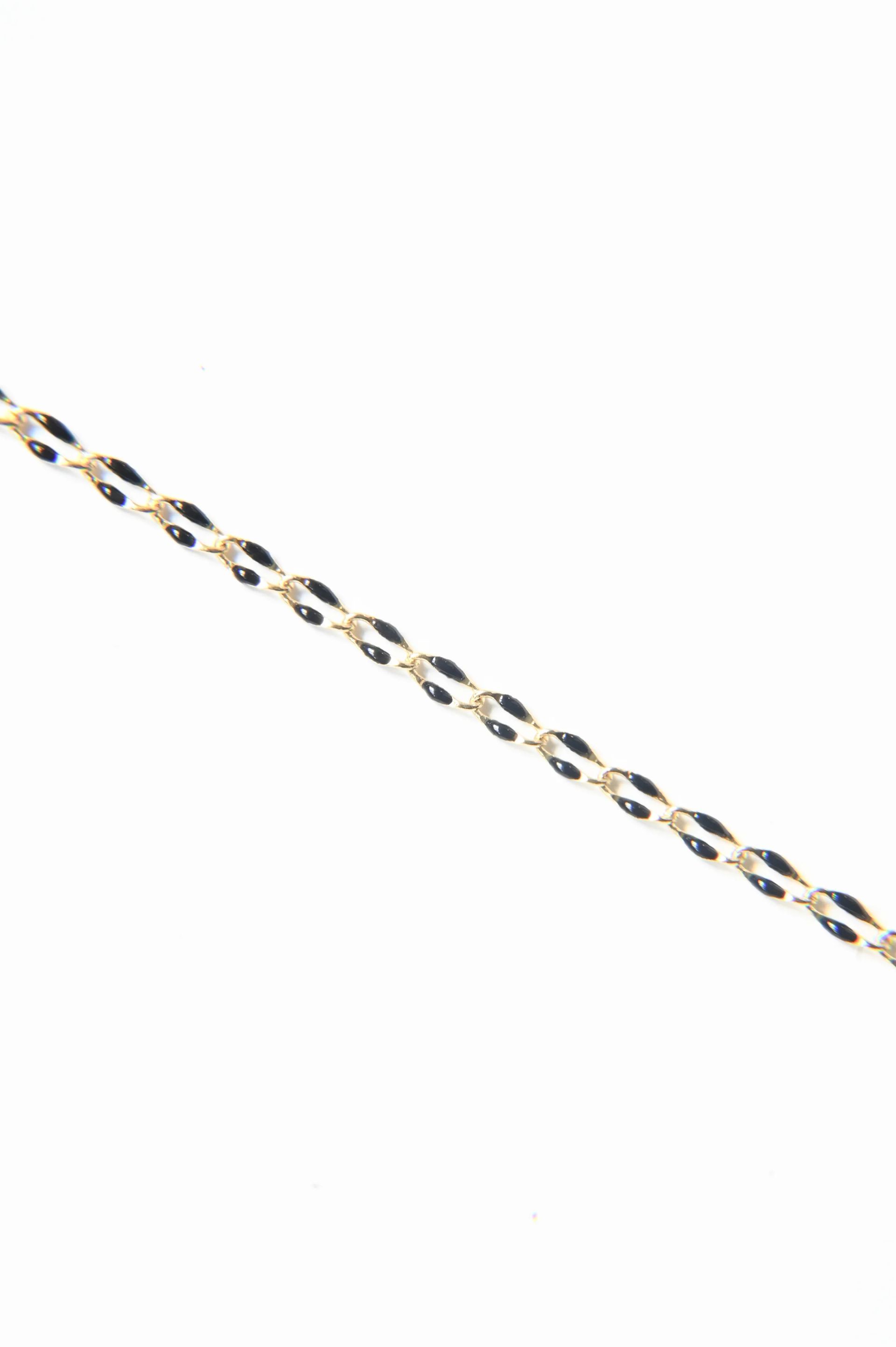 A close up of a gold chain on a white background.
