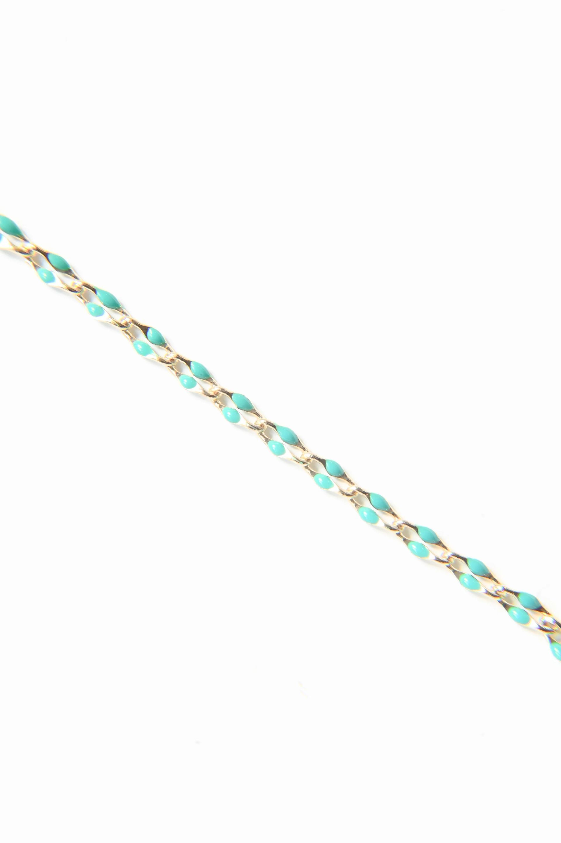 A close up of a turquoise and gold chain on a white background.
