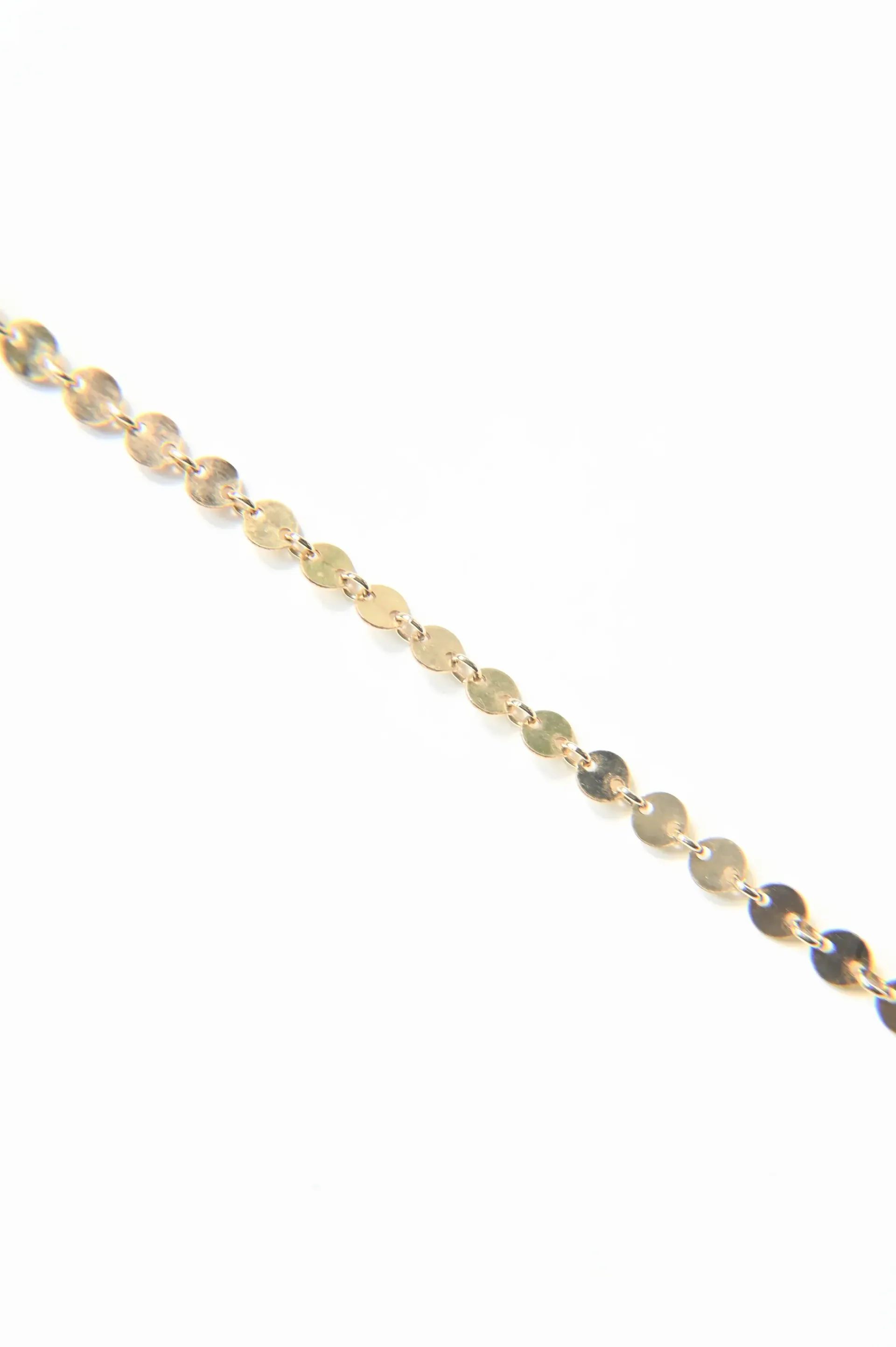 A close up of a gold chain on a white background.