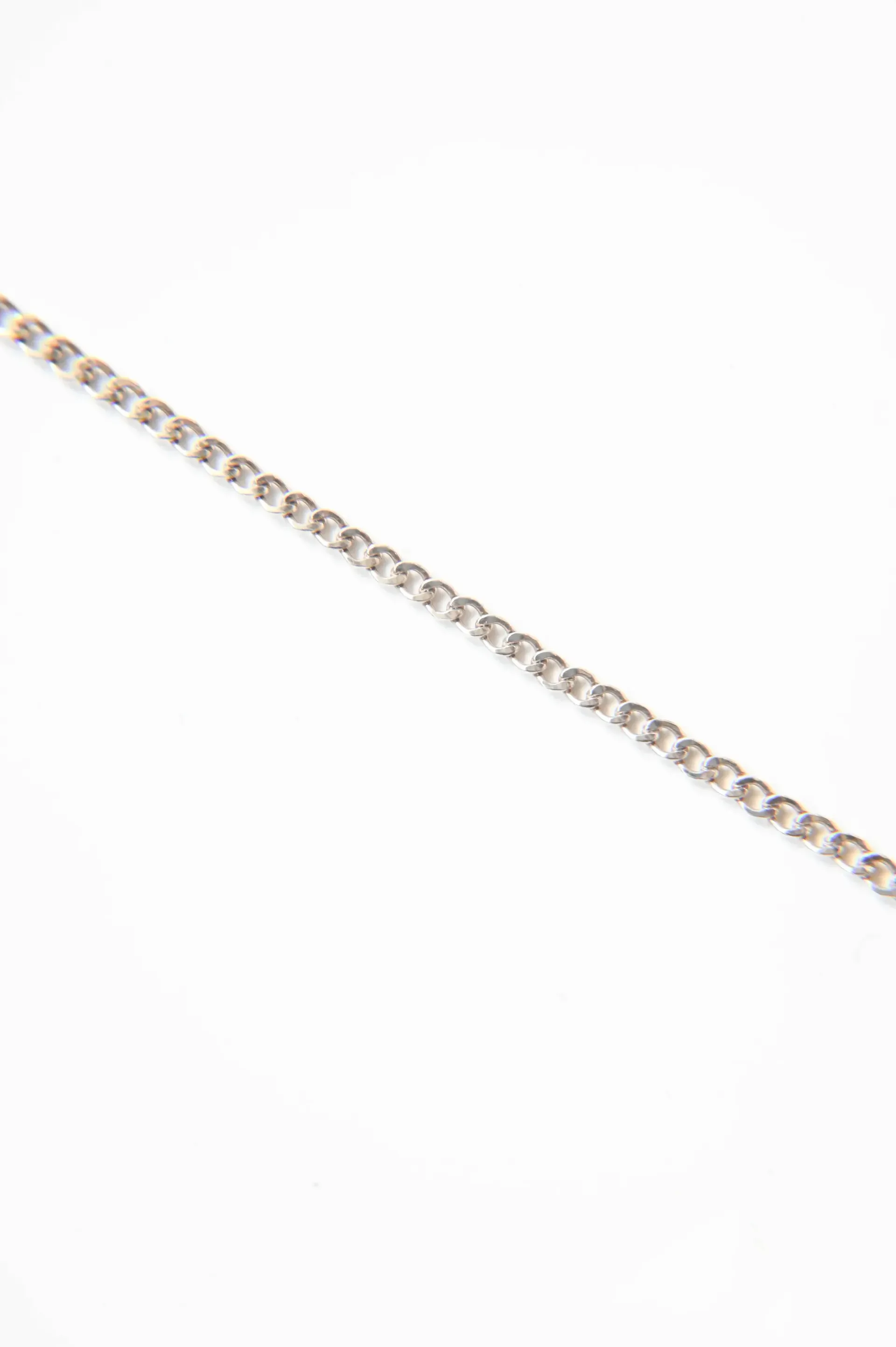 A close up of a gold chain on a white background.