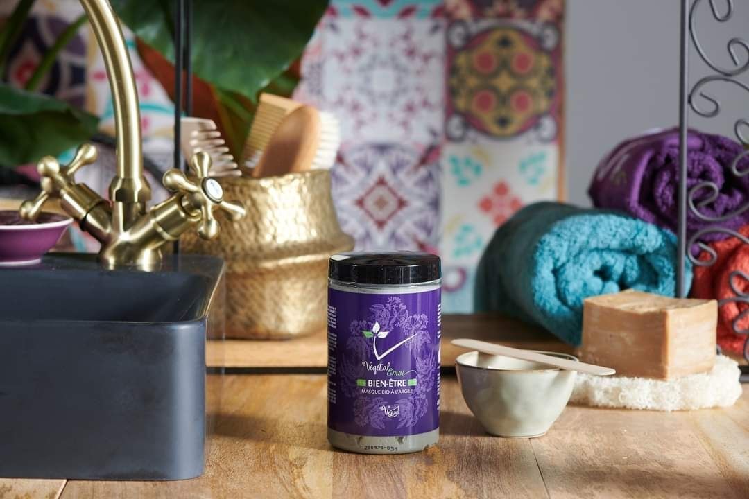 Une bouteille de savon est posée sur une table en bois à côté d'un évier.