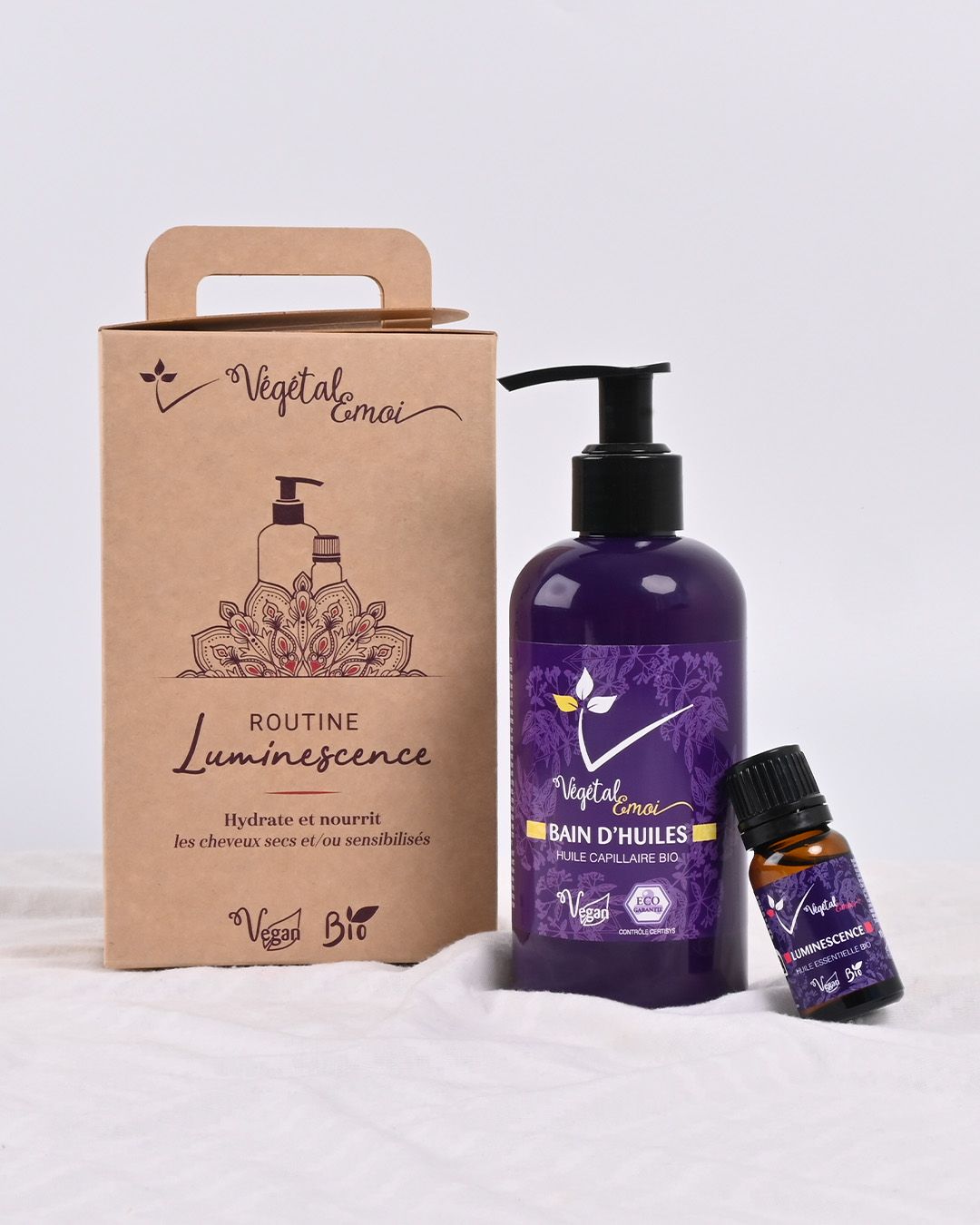 Un flacon de lotion et un flacon d'huile essentielle sont dans une boîte.