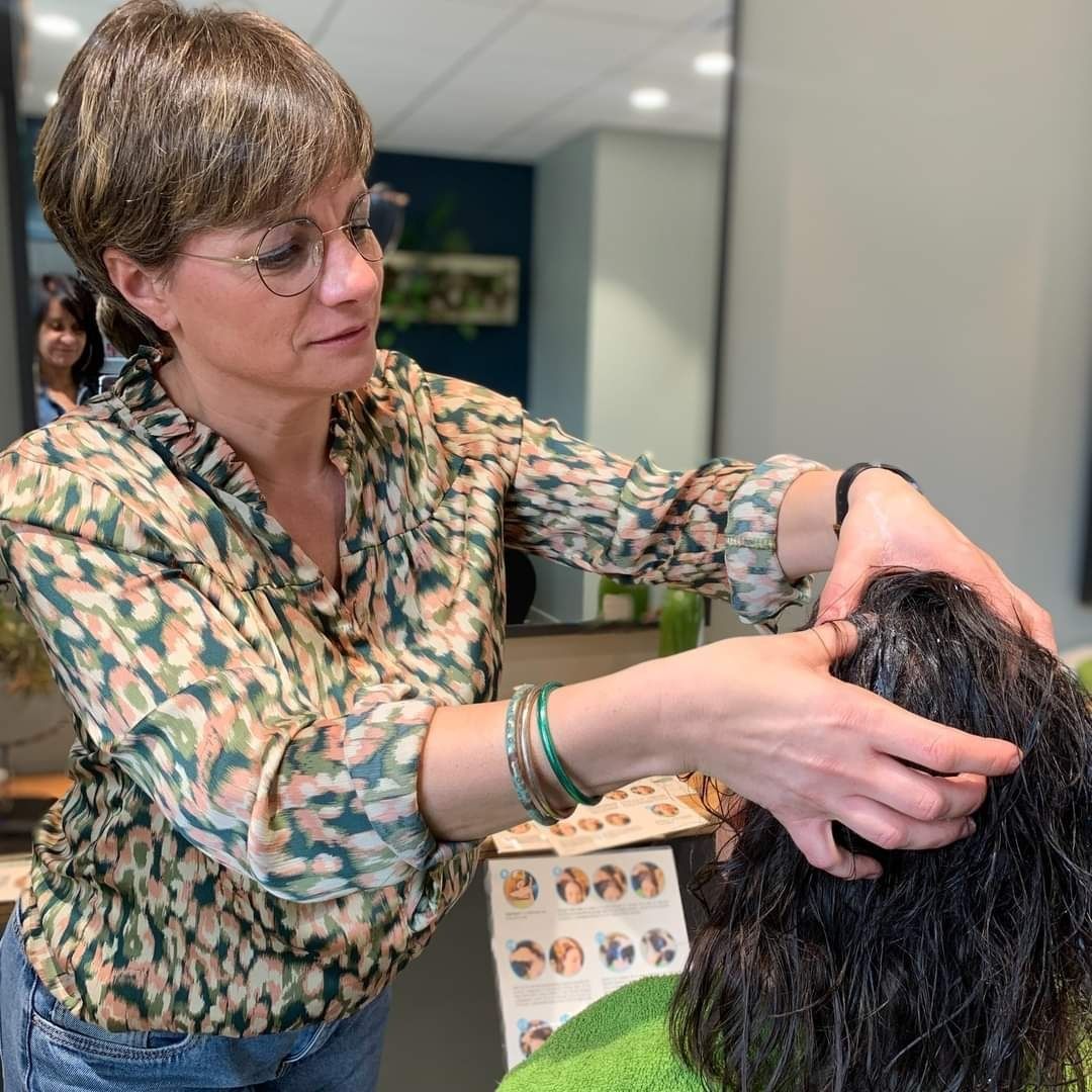 Une femme coupe les cheveux d'une femme dans un salon.