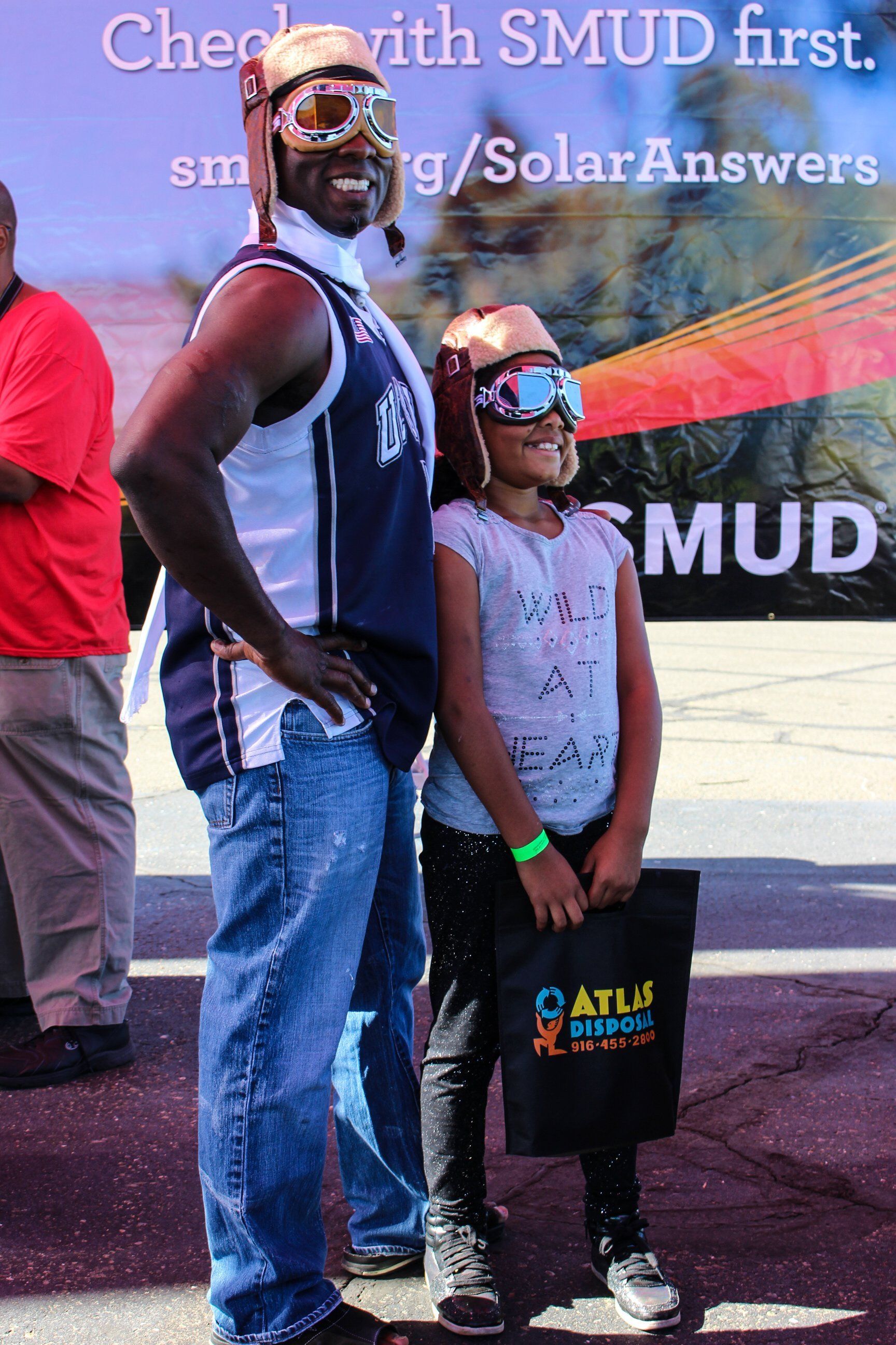 A man and a girl are standing in front of a sign that says check with smud first