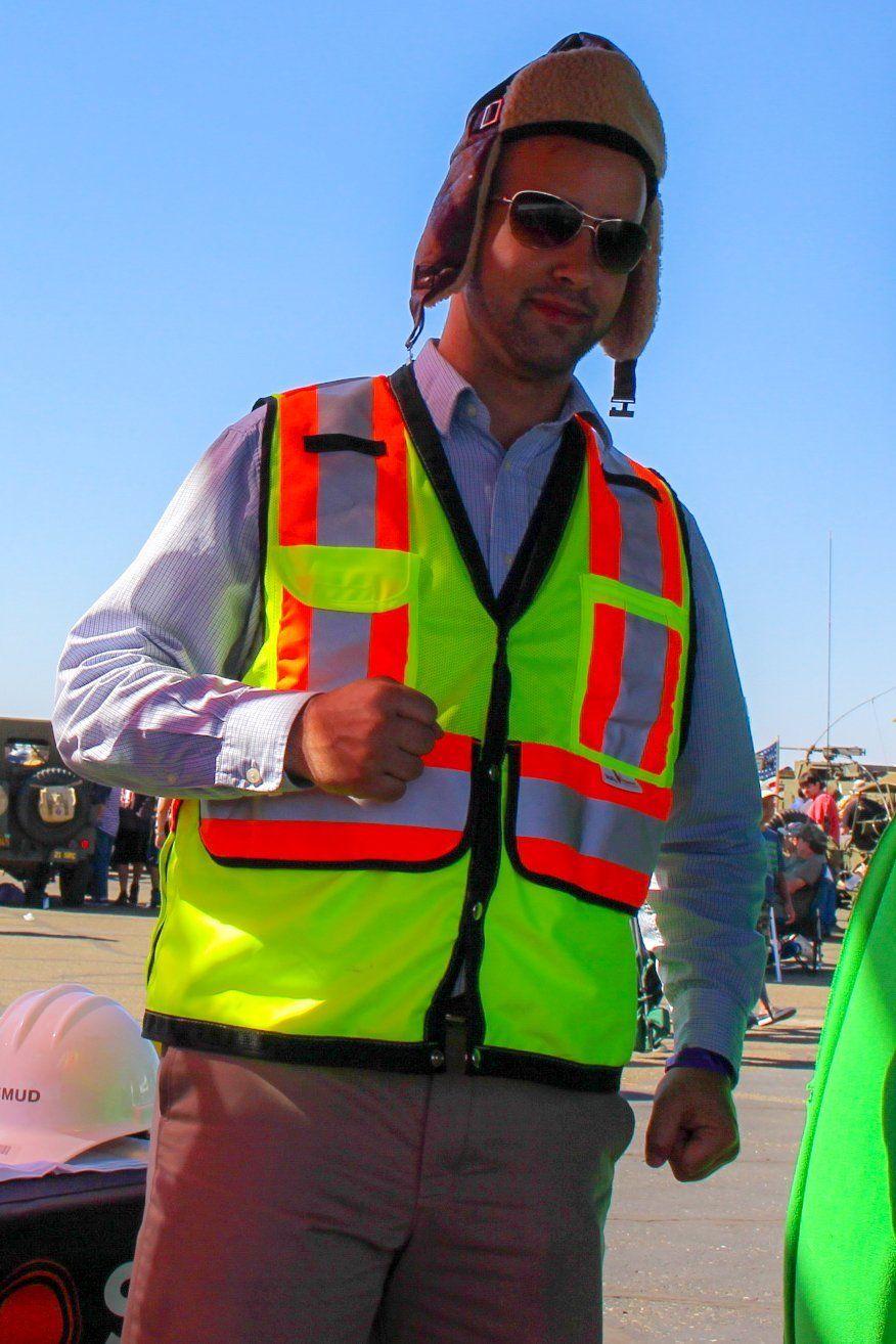 A man wearing a yellow safety vest and a hat