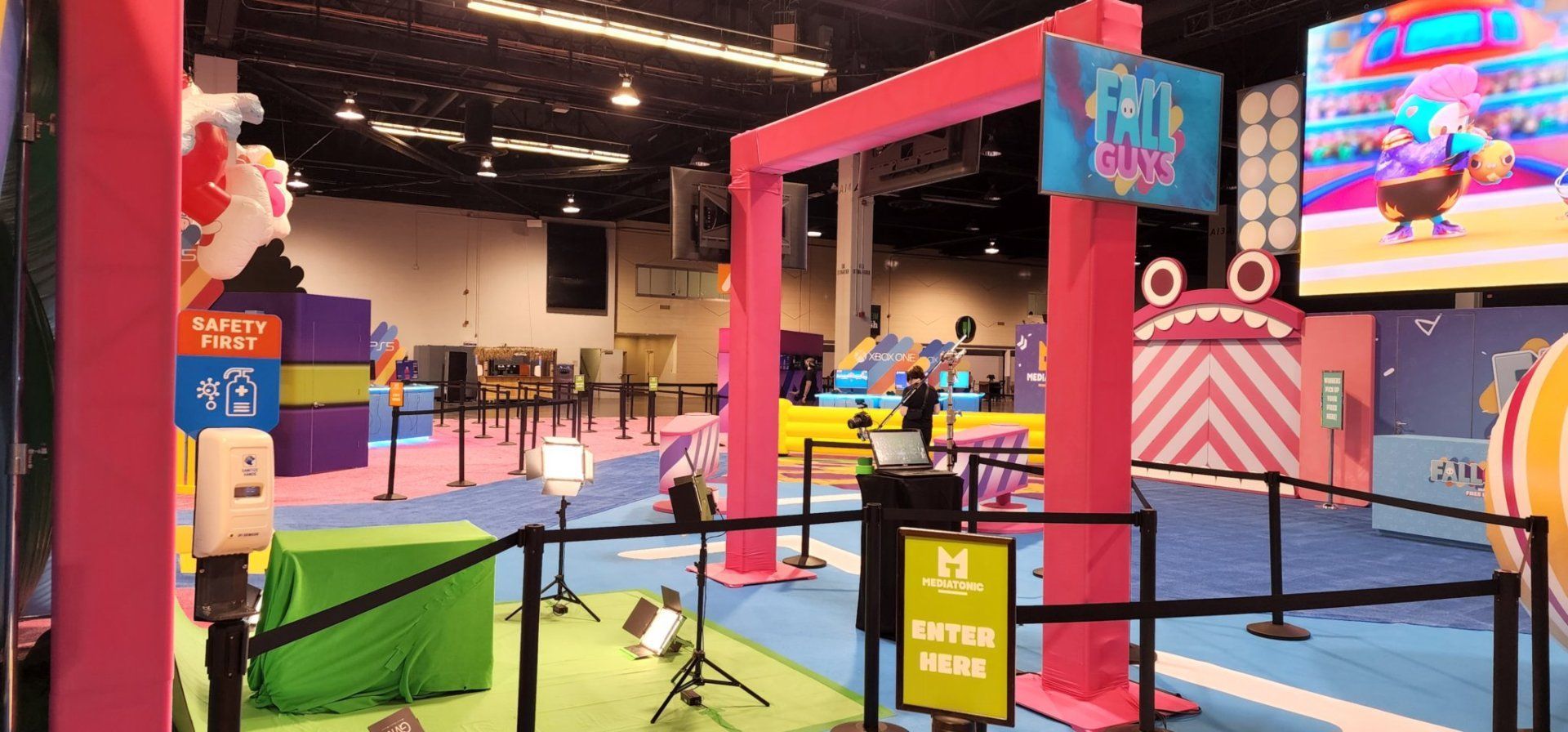 A large room with a lot of pink and blue decorations and a large screen.