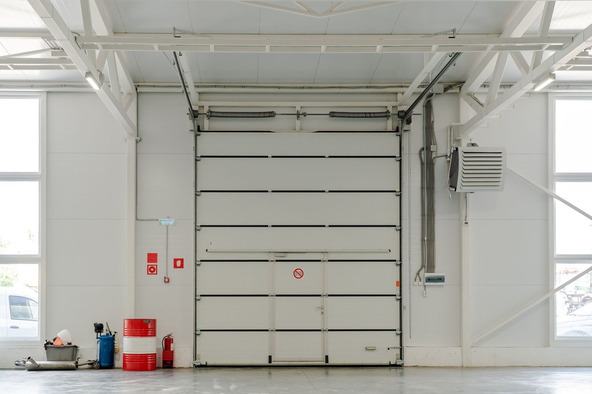 Industrial garage door in a modern warehouse interior with a fire safety system.