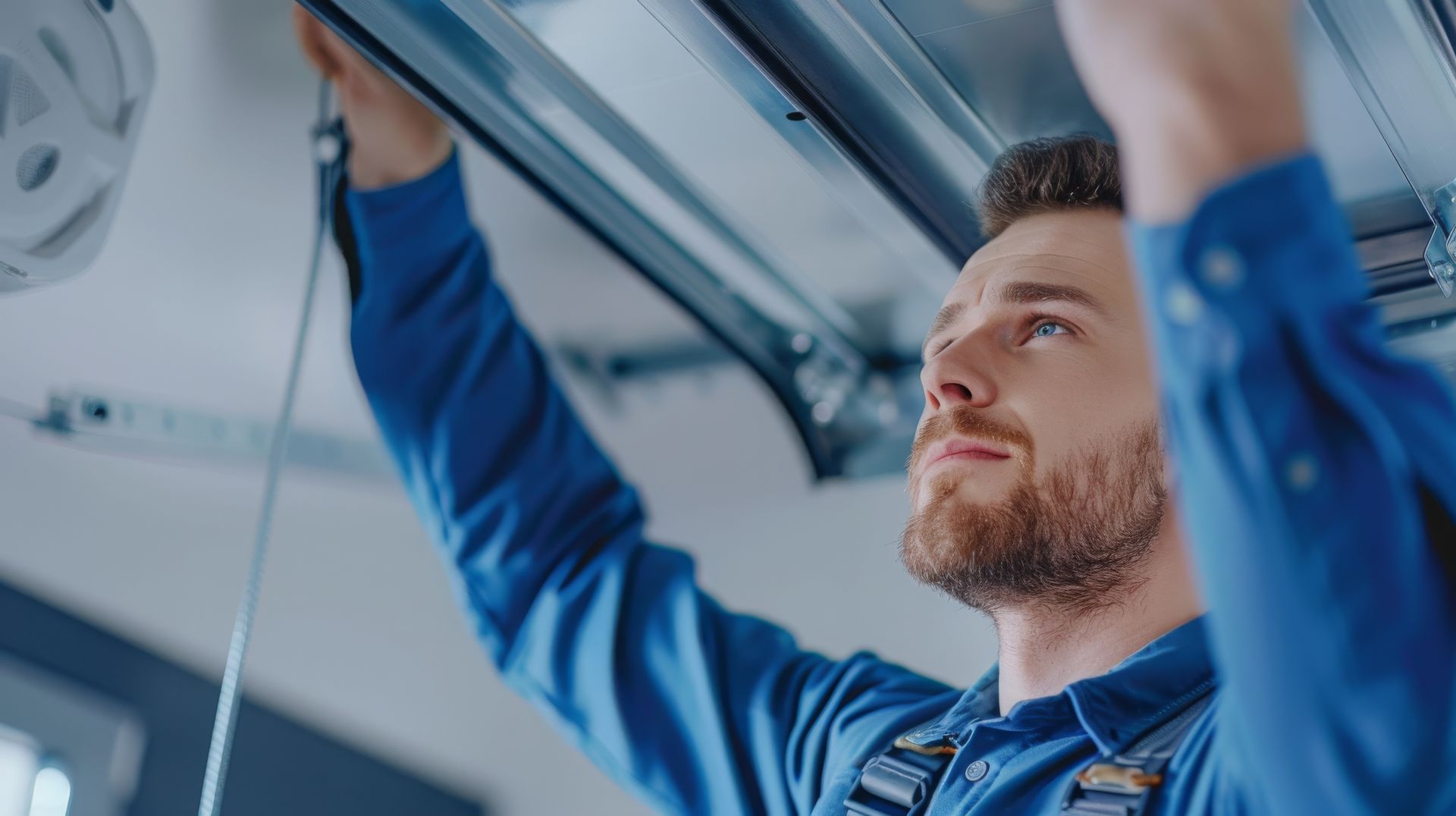 Contractor repairing a garage door opener.