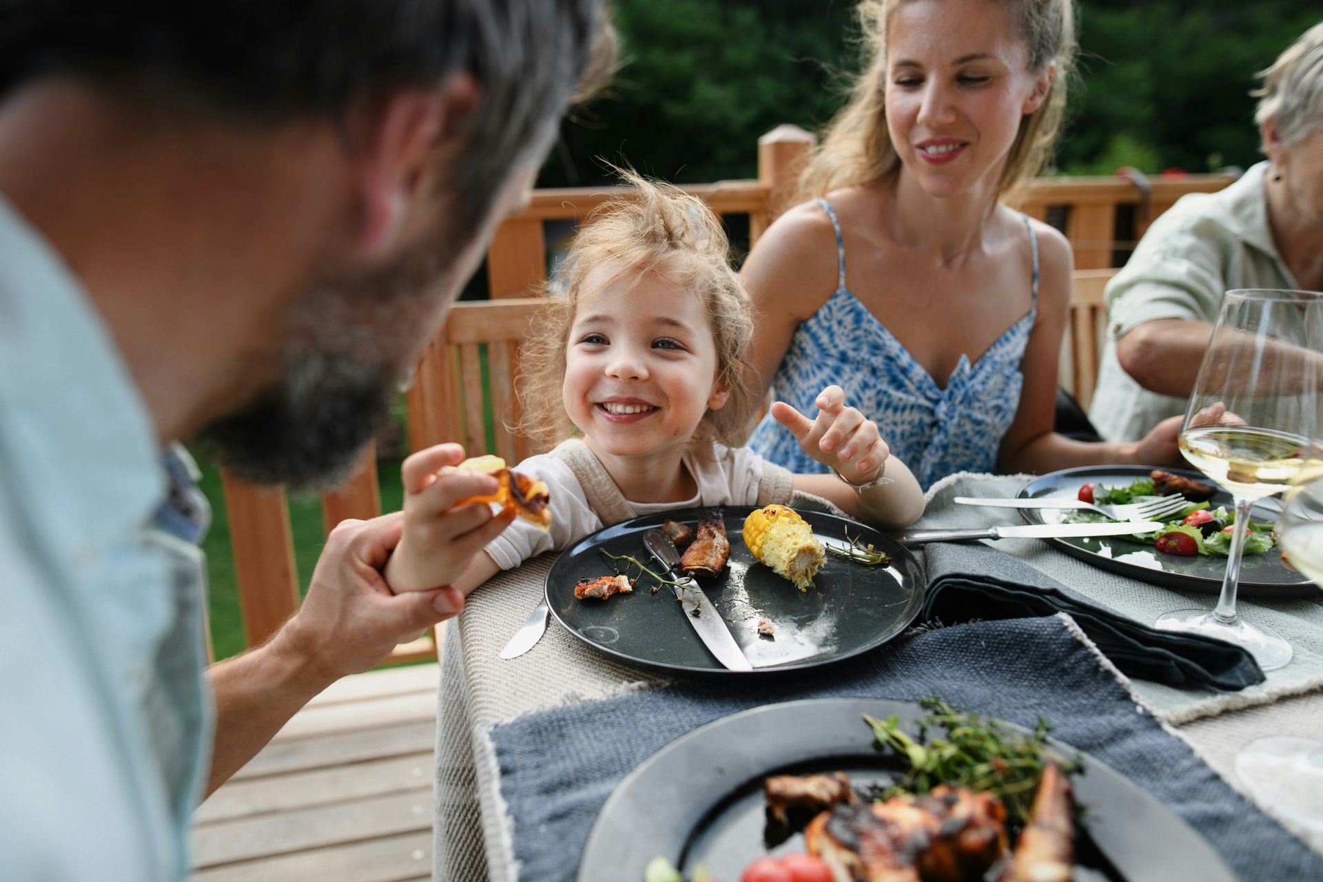 A family is sitting at a table eating food.