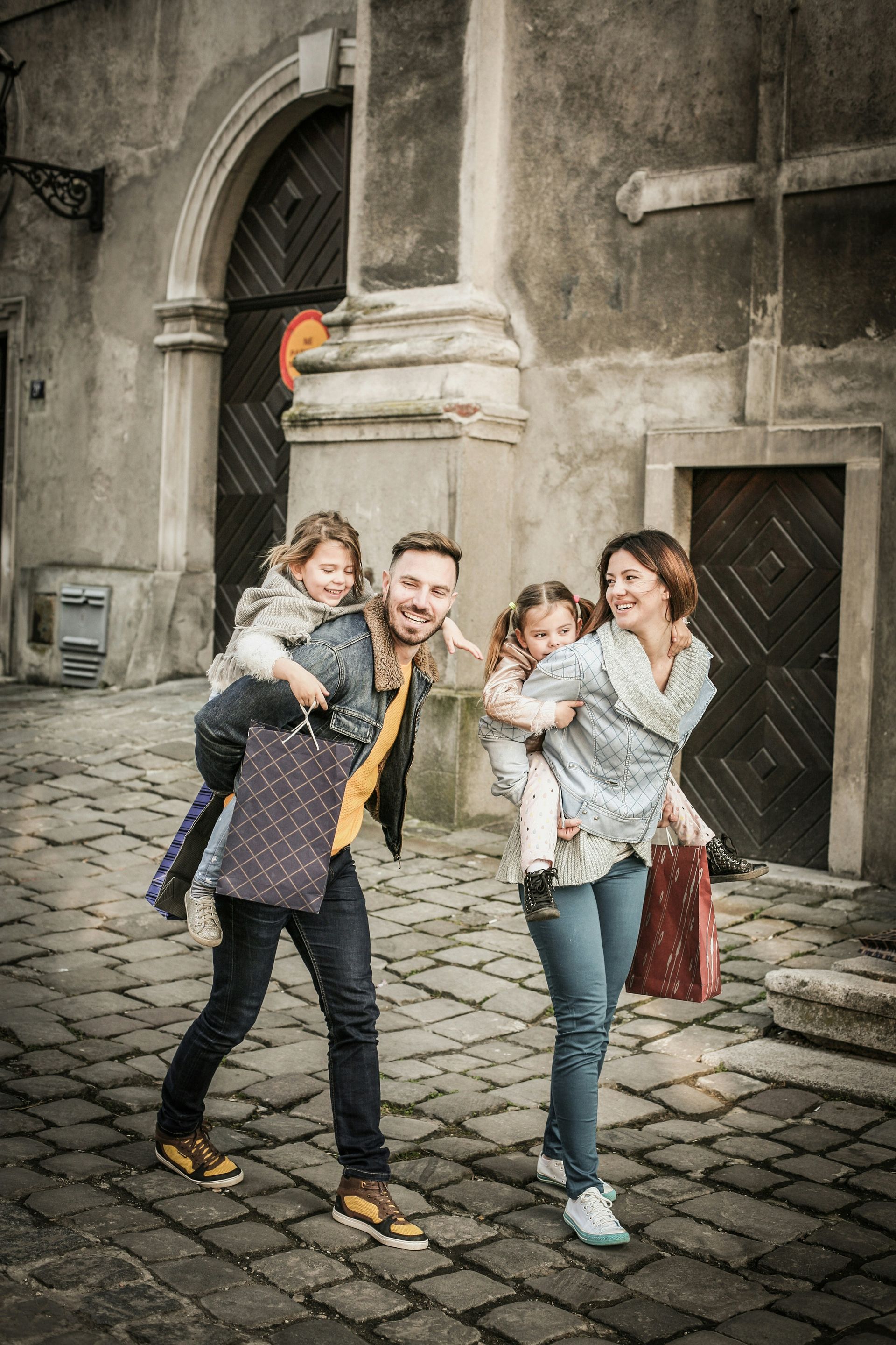A family is walking down a cobblestone street.