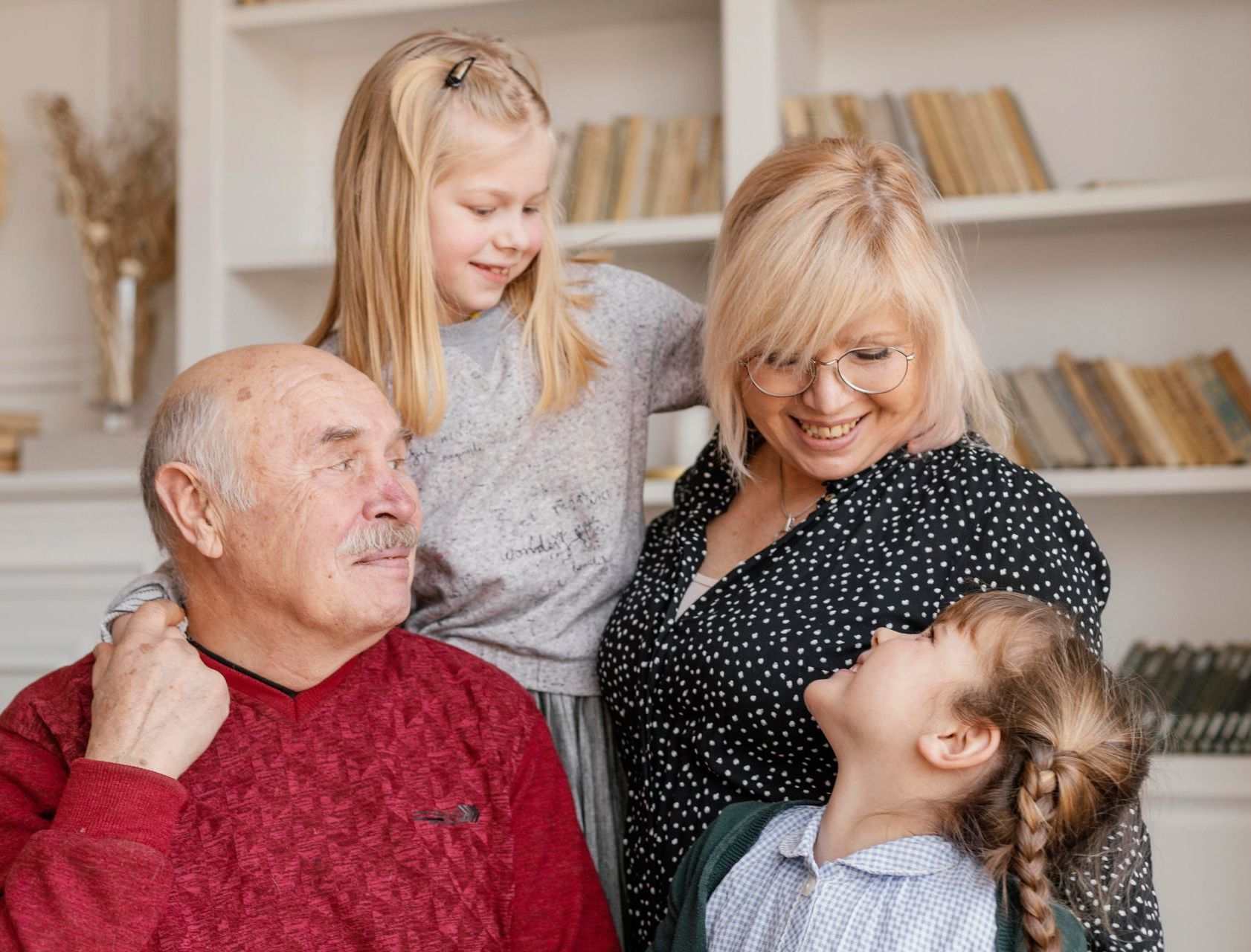 A family is posing for a picture together in a living room.