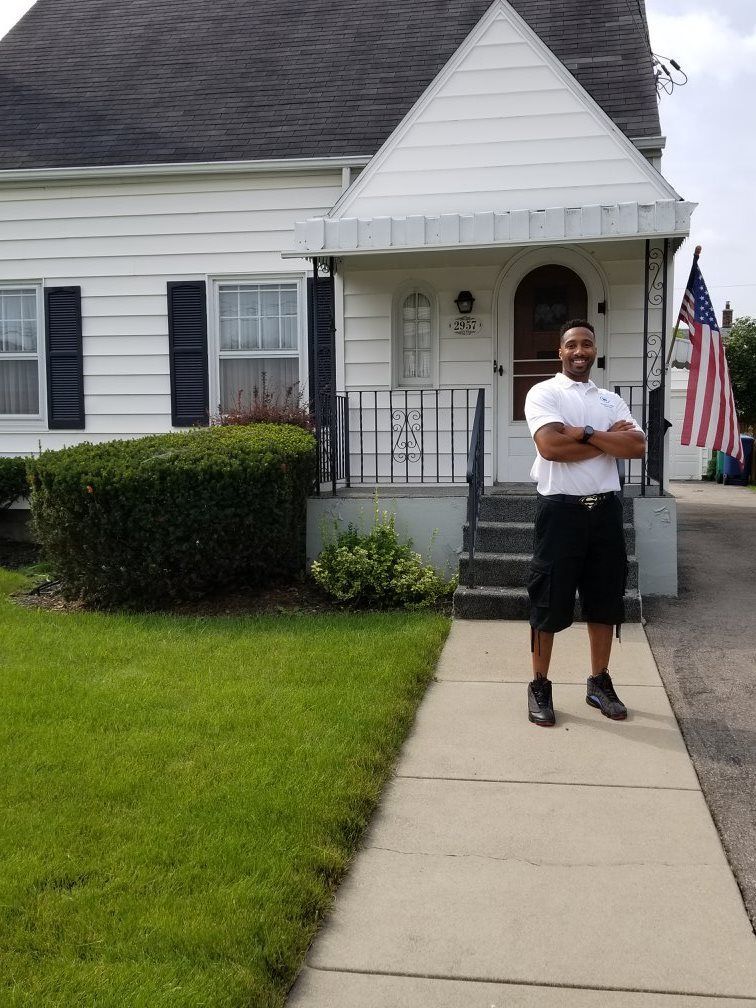 A plumber working under a kitchen sink, holding a wrench, inspecting pipes.