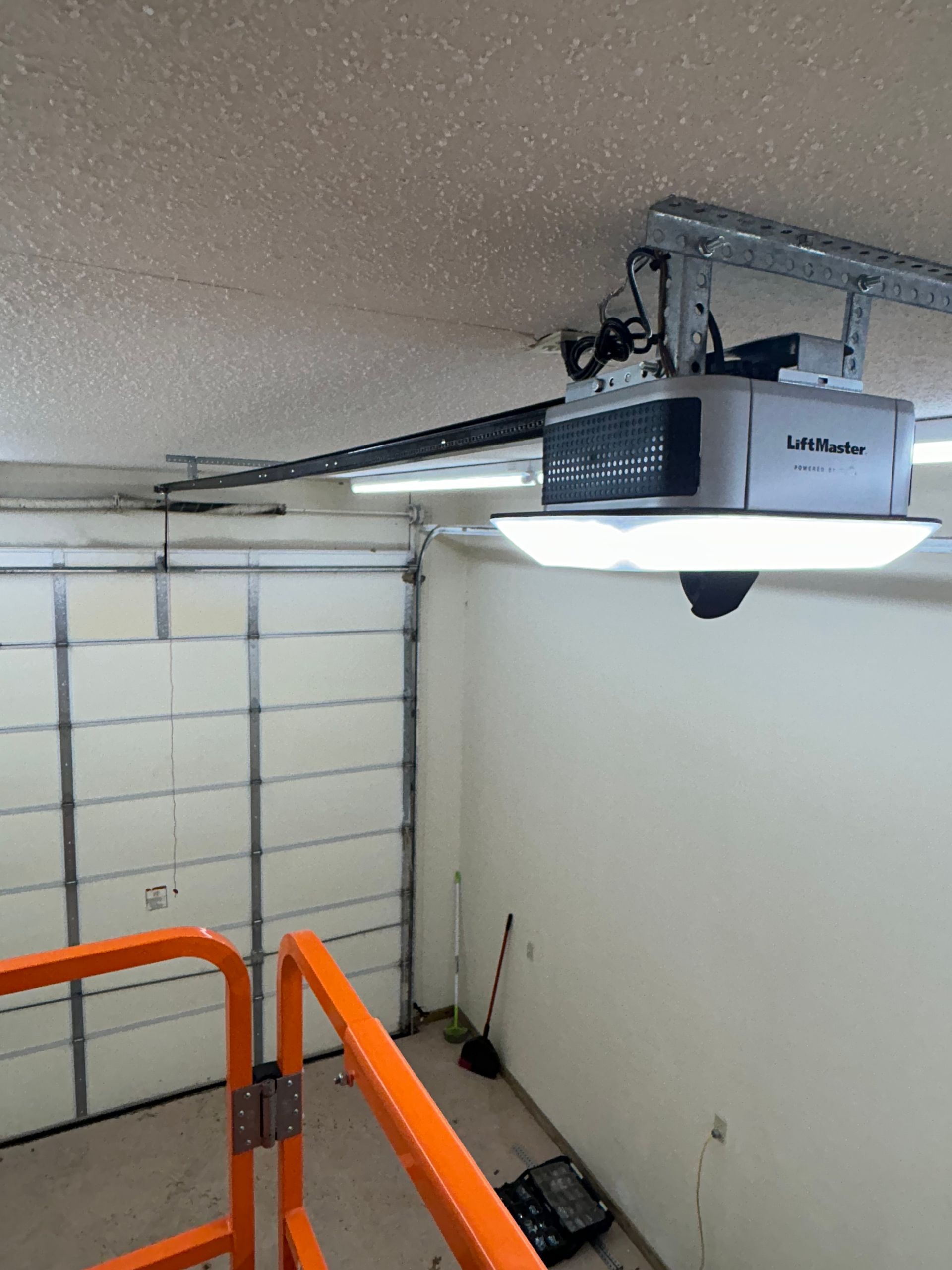 Garage with an automatic door opener mounted on the ceiling.