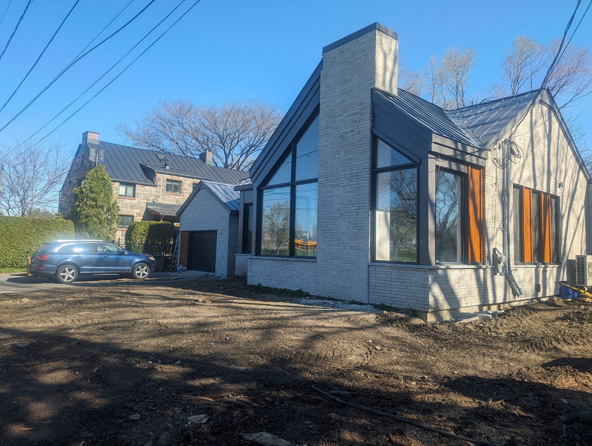 Une maison avec beaucoup de fenêtres et une voiture garée devant.