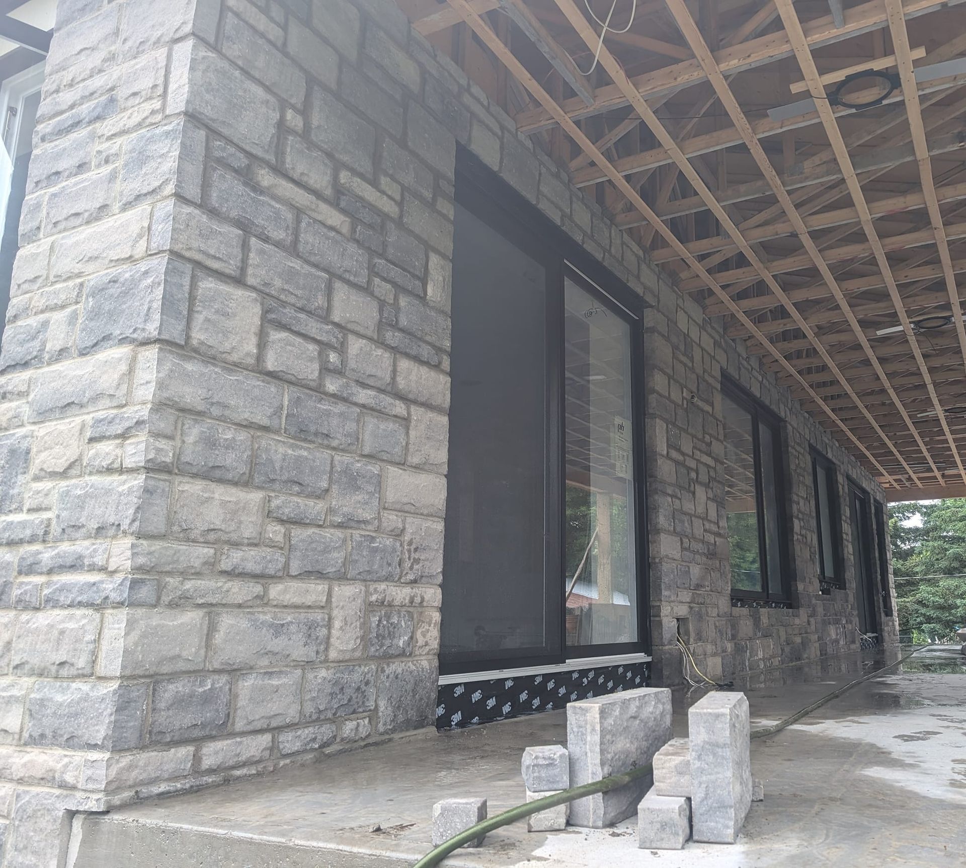 Un bâtiment en briques avec une porte coulissante en verre et un plafond en bois