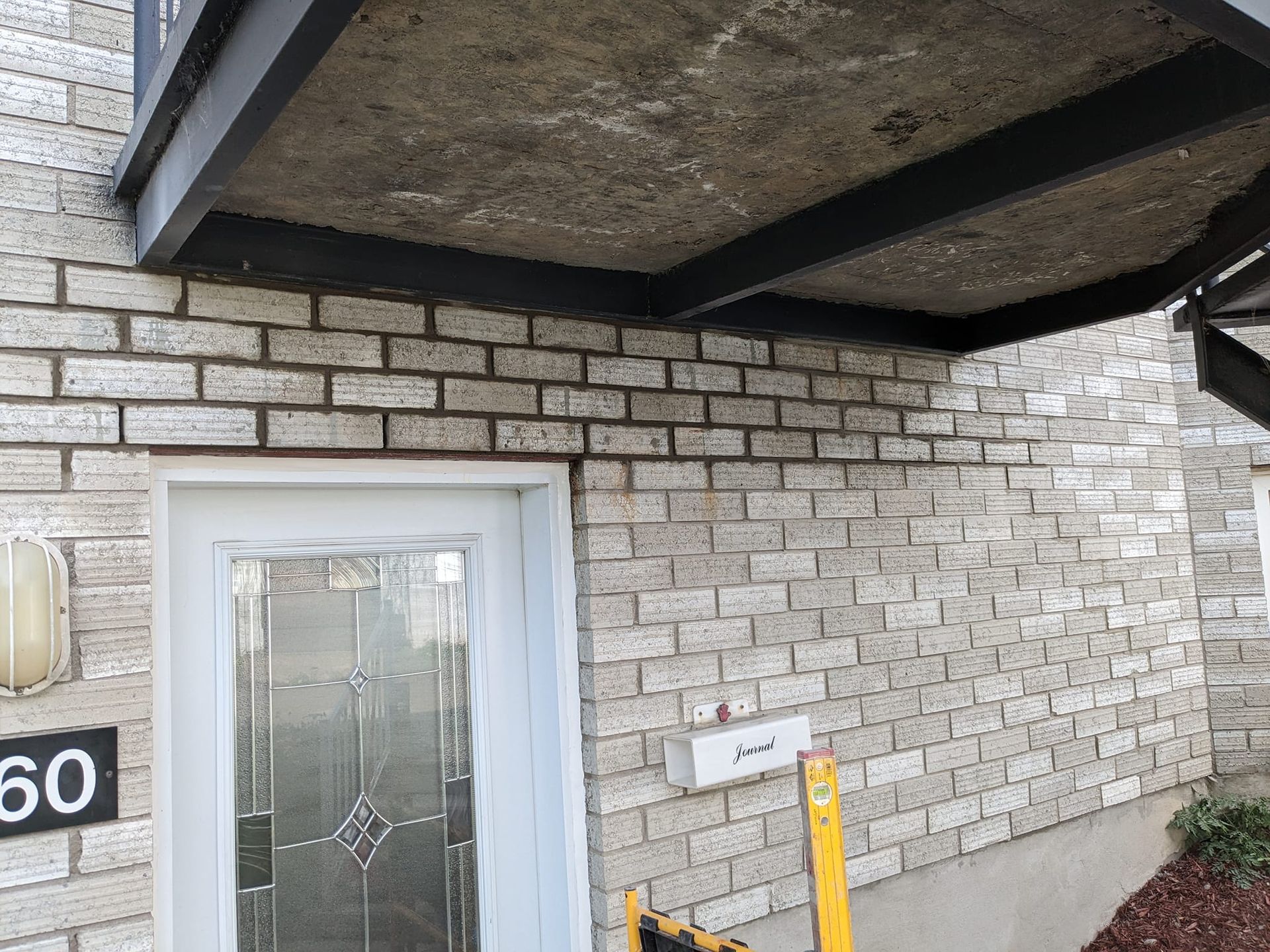 Un bâtiment en briques avec une porte et un auvent au-dessus.