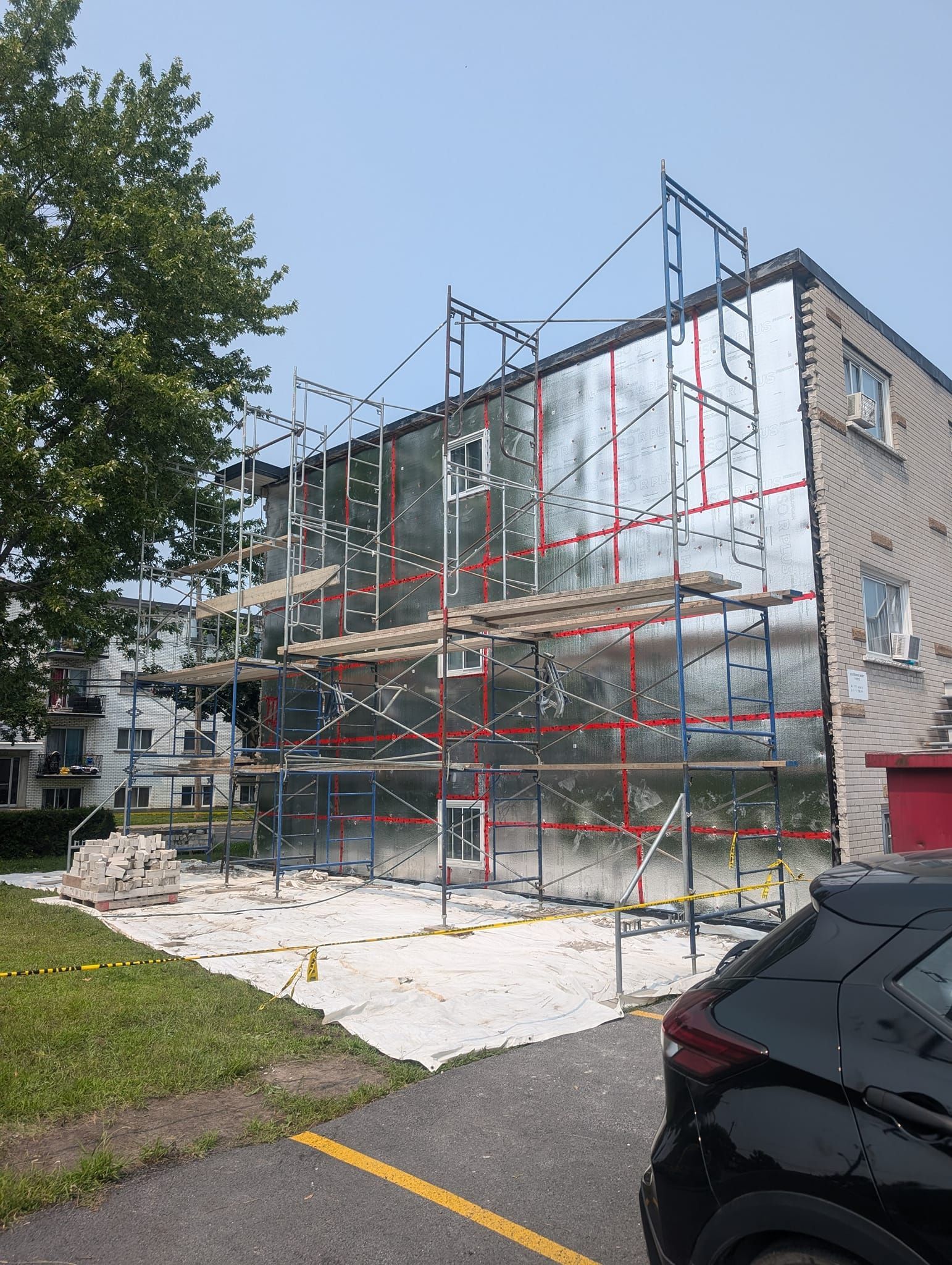 Une voiture est garée devant un immeuble en construction.