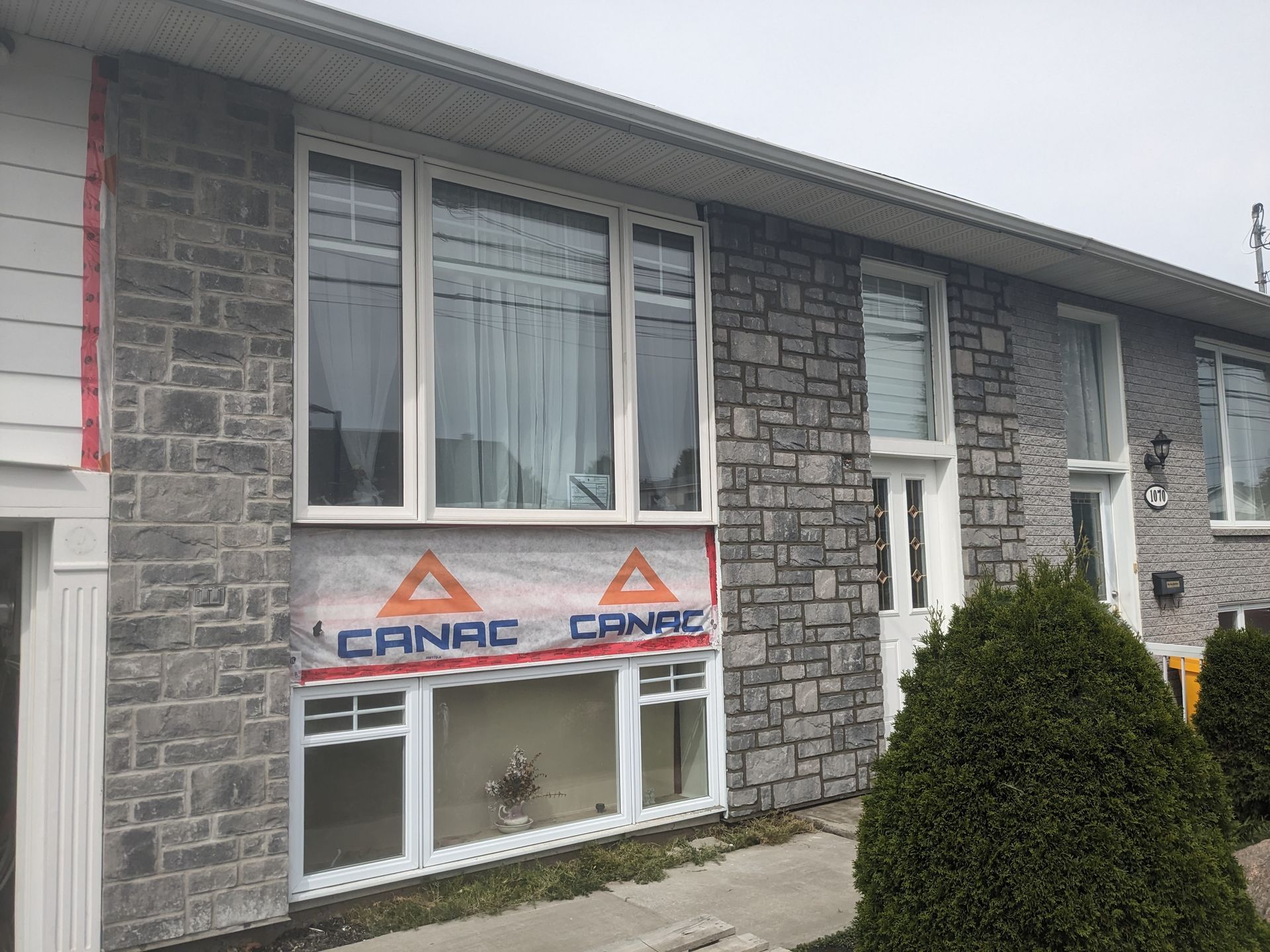 Une maison en briques avec beaucoup de fenêtres est en cours de rénovation.