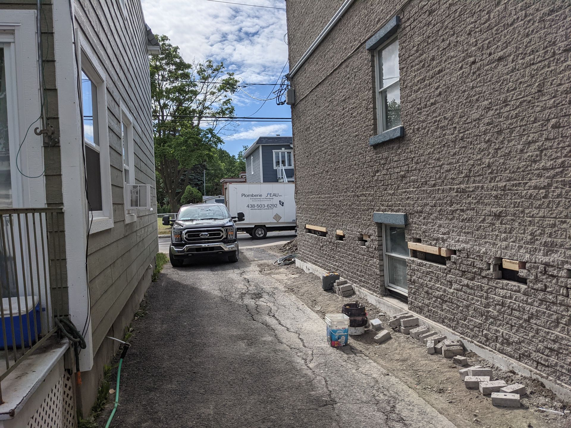 Une voiture est garée dans une ruelle étroite entre deux bâtiments.