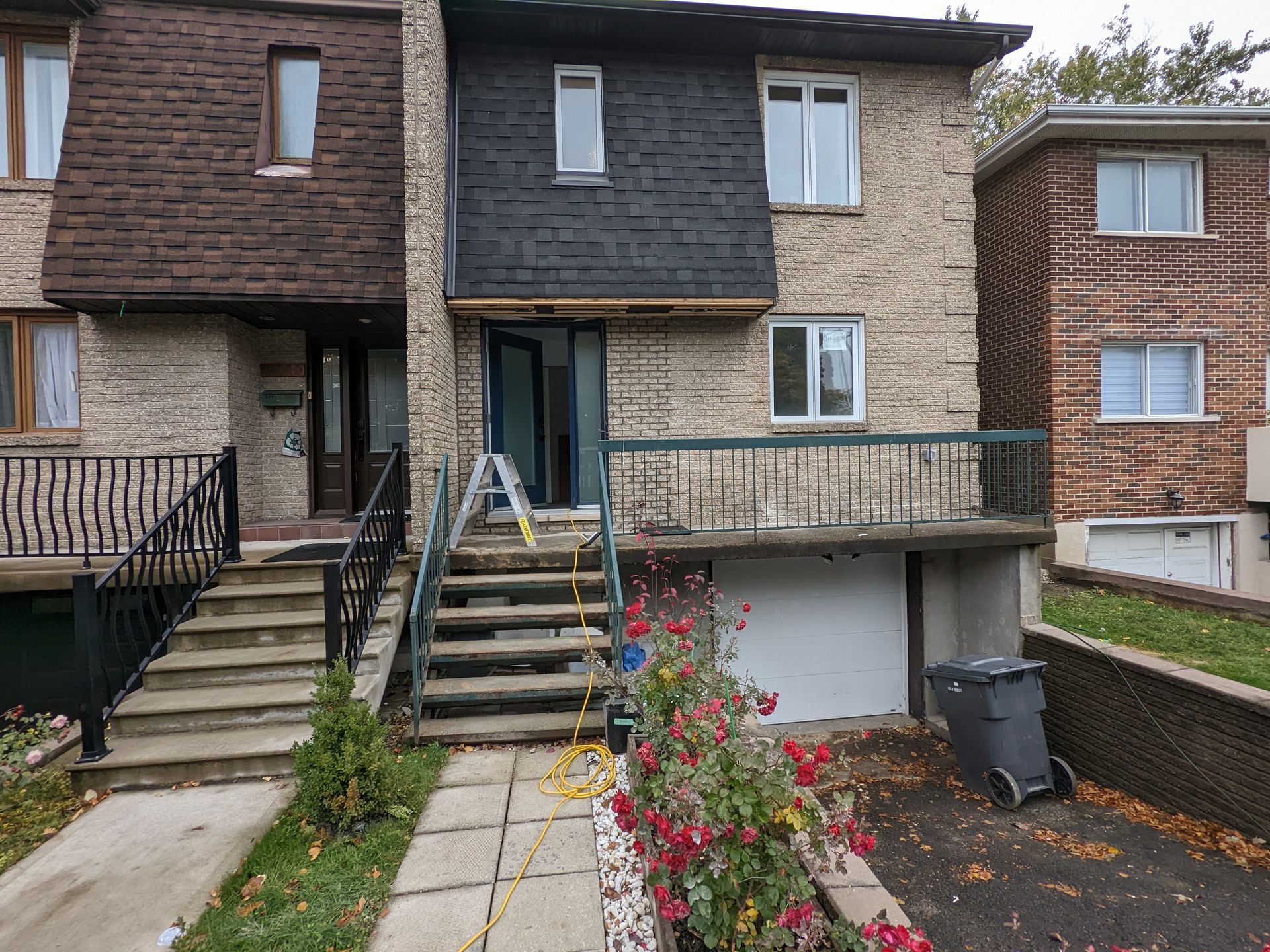Une maison en briques avec des escaliers menant à la porte d'entrée