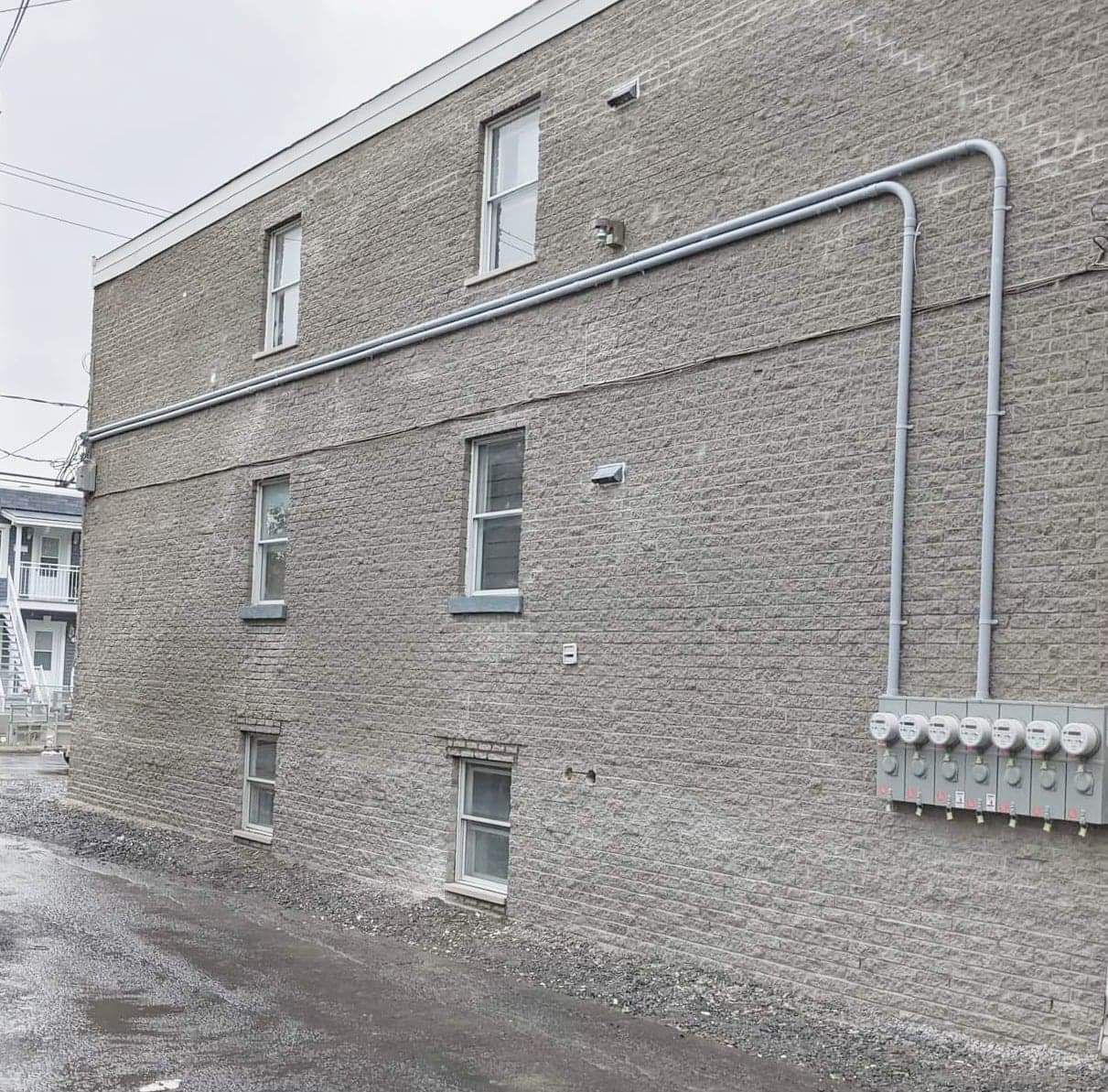 Un bâtiment en briques avec beaucoup de fenêtres et un tuyau qui en sort