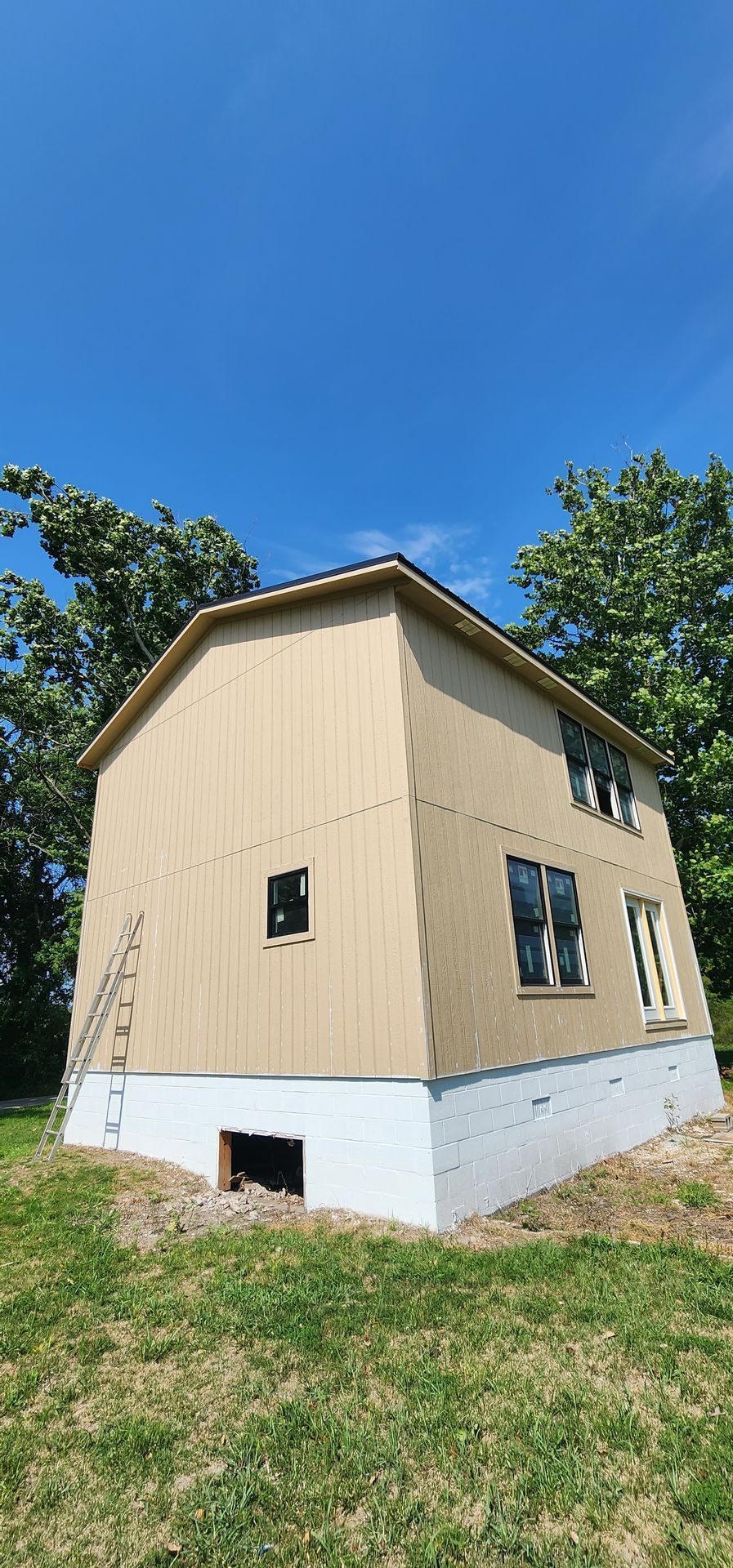 A small house is being built in the middle of a grassy field — Overland Park, KS — Johnson County Solutions