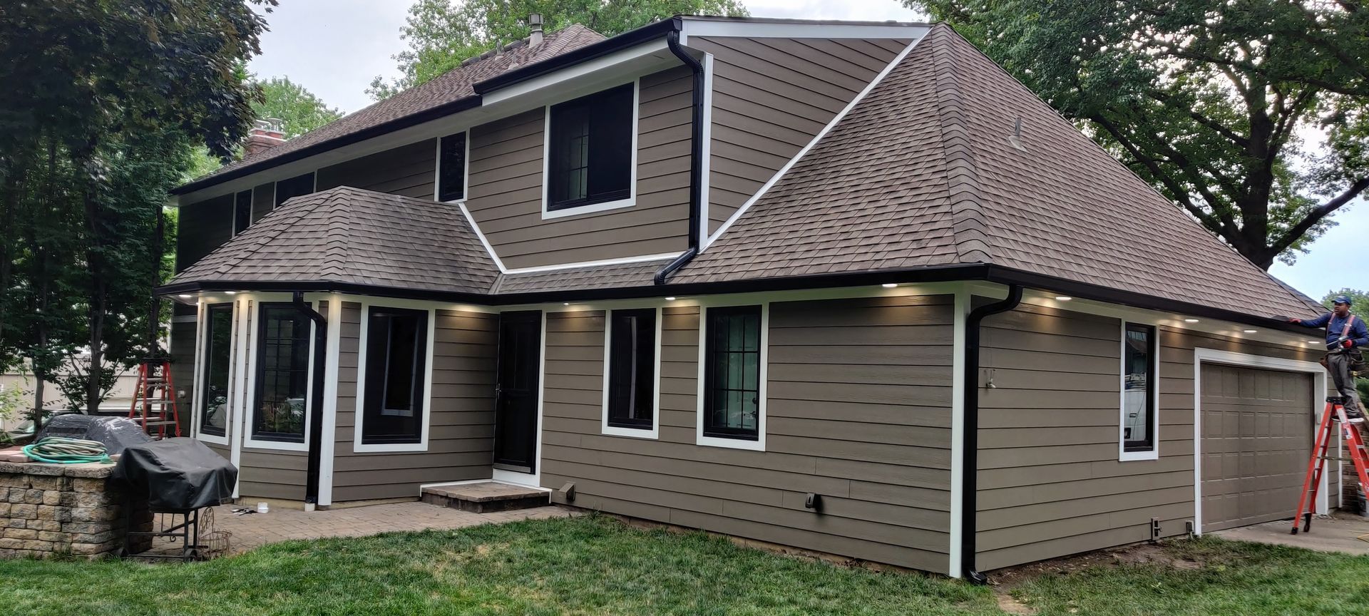 A large house with a brown roof is sitting on top of a lush green field — Overland Park, KS — Johnson County Solutions