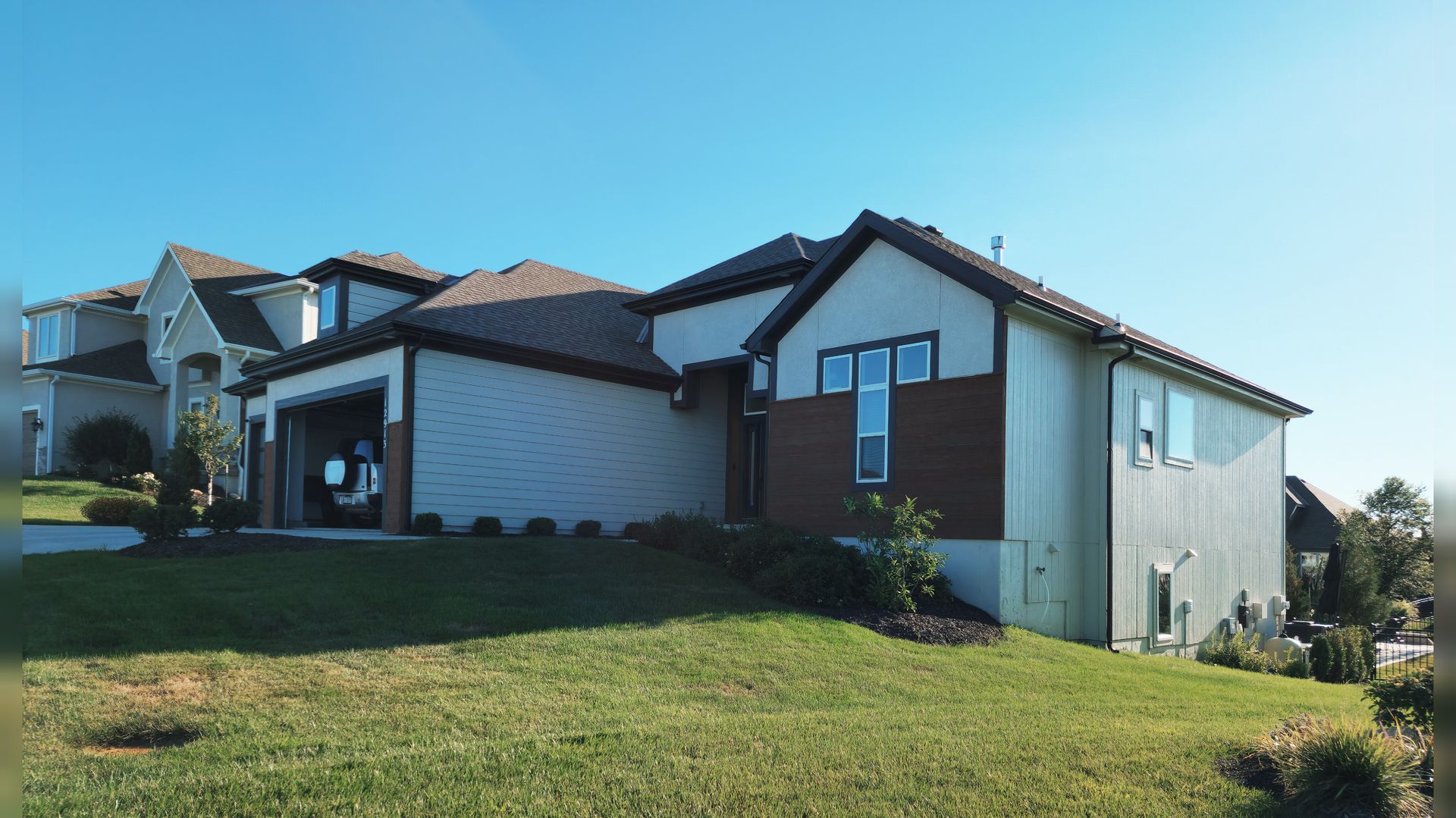 A large house is sitting on top of a lush green hillside — Overland Park, KS — Johnson County Solutions
