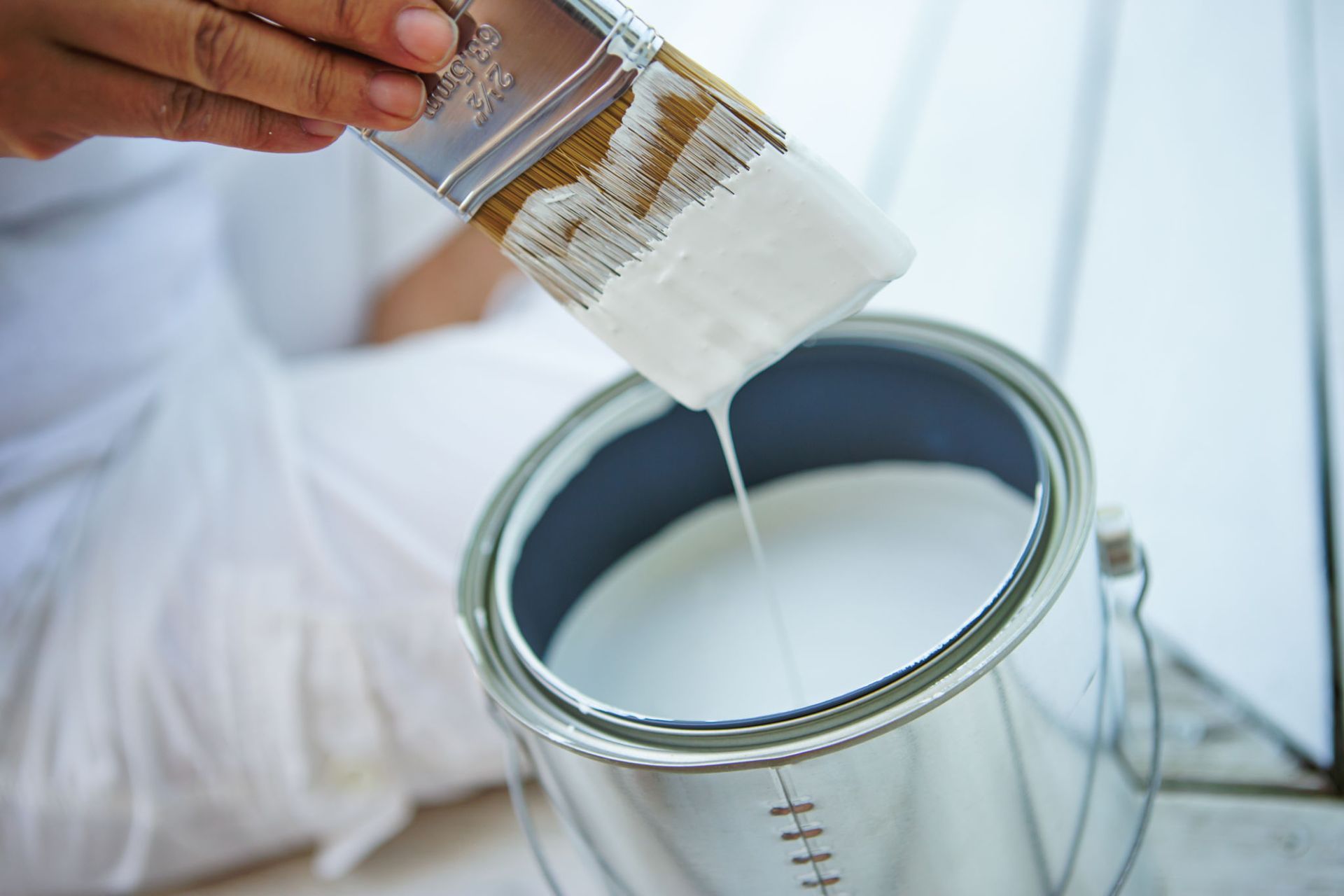 A person is pouring paint from a brush into a can — Overland Park, KS — Johnson County Solutions