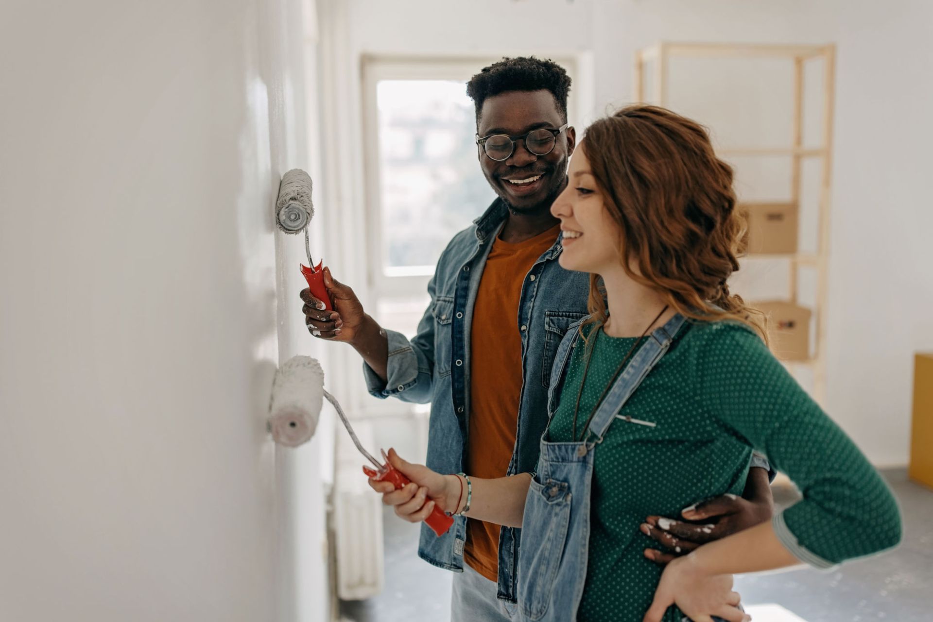 A man and a woman are painting a wall together — Overland Park, KS — Johnson County Solutions