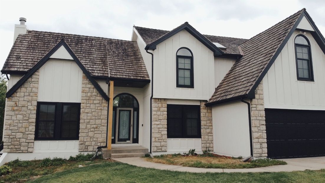 A white house with a brown roof and black windows — Overland Park, KS — Johnson County Solutions