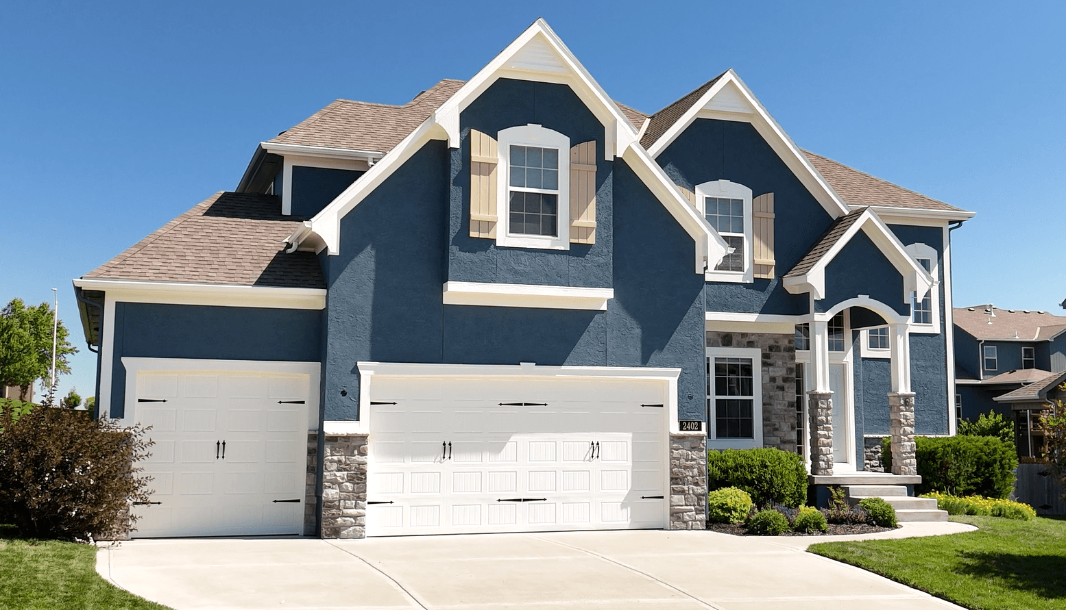A large blue and white house with a white garage door — Overland Park, KS — Johnson County Solutions