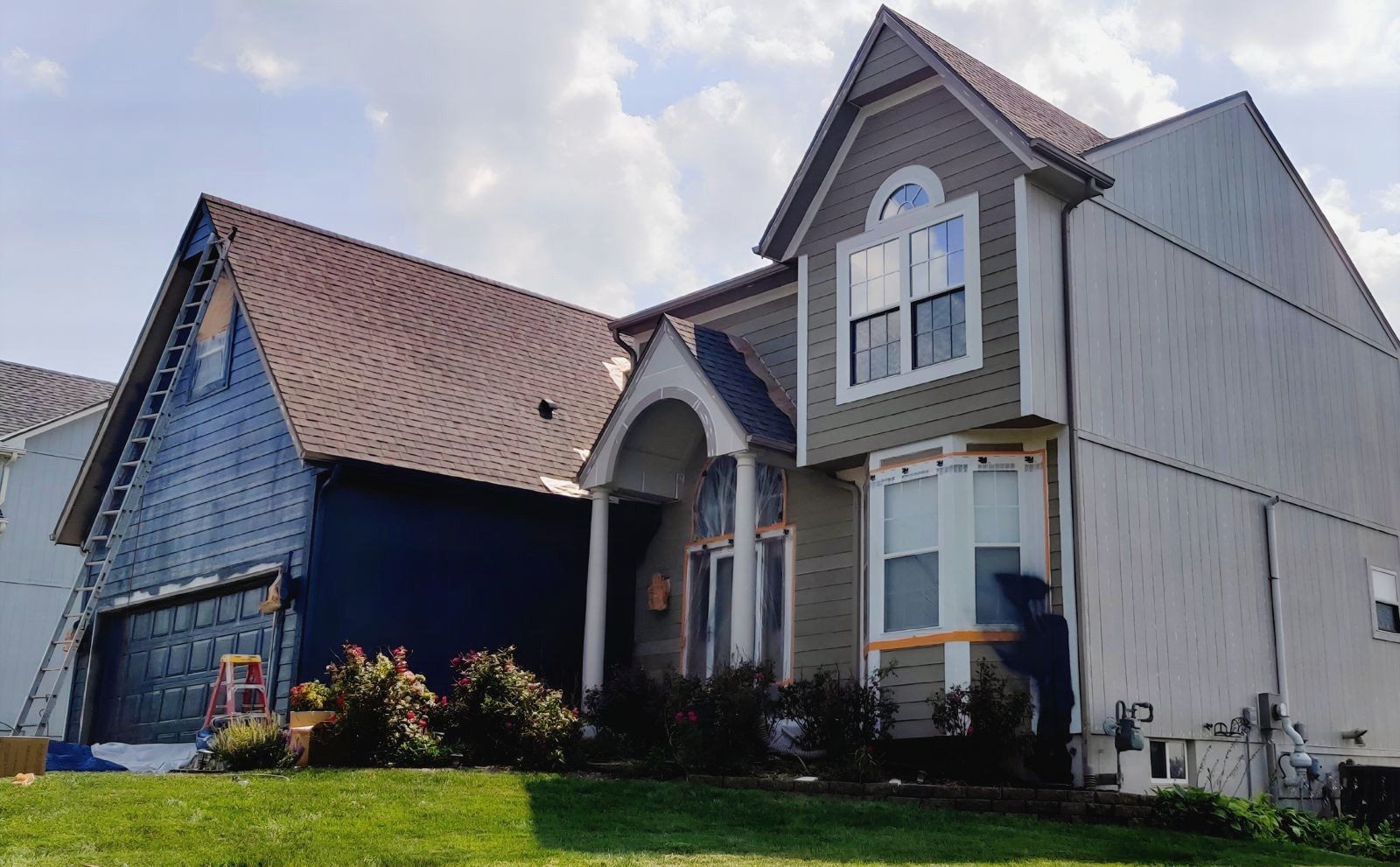 A large house is being painted blue and white — Overland Park, KS — Johnson County Solutions