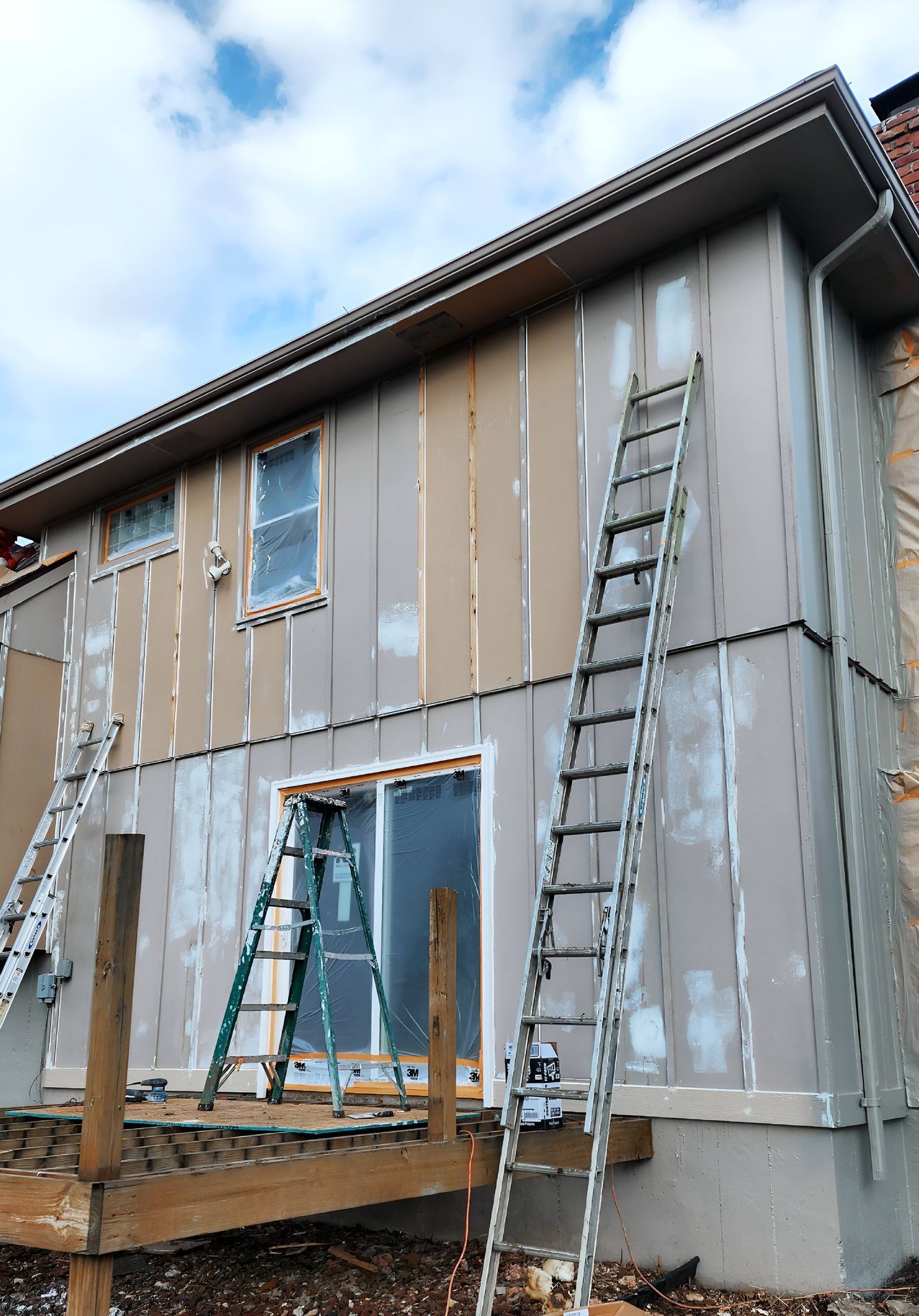A house is being painted with ladders on the side of it — Overland Park, KS — Johnson County Solutions