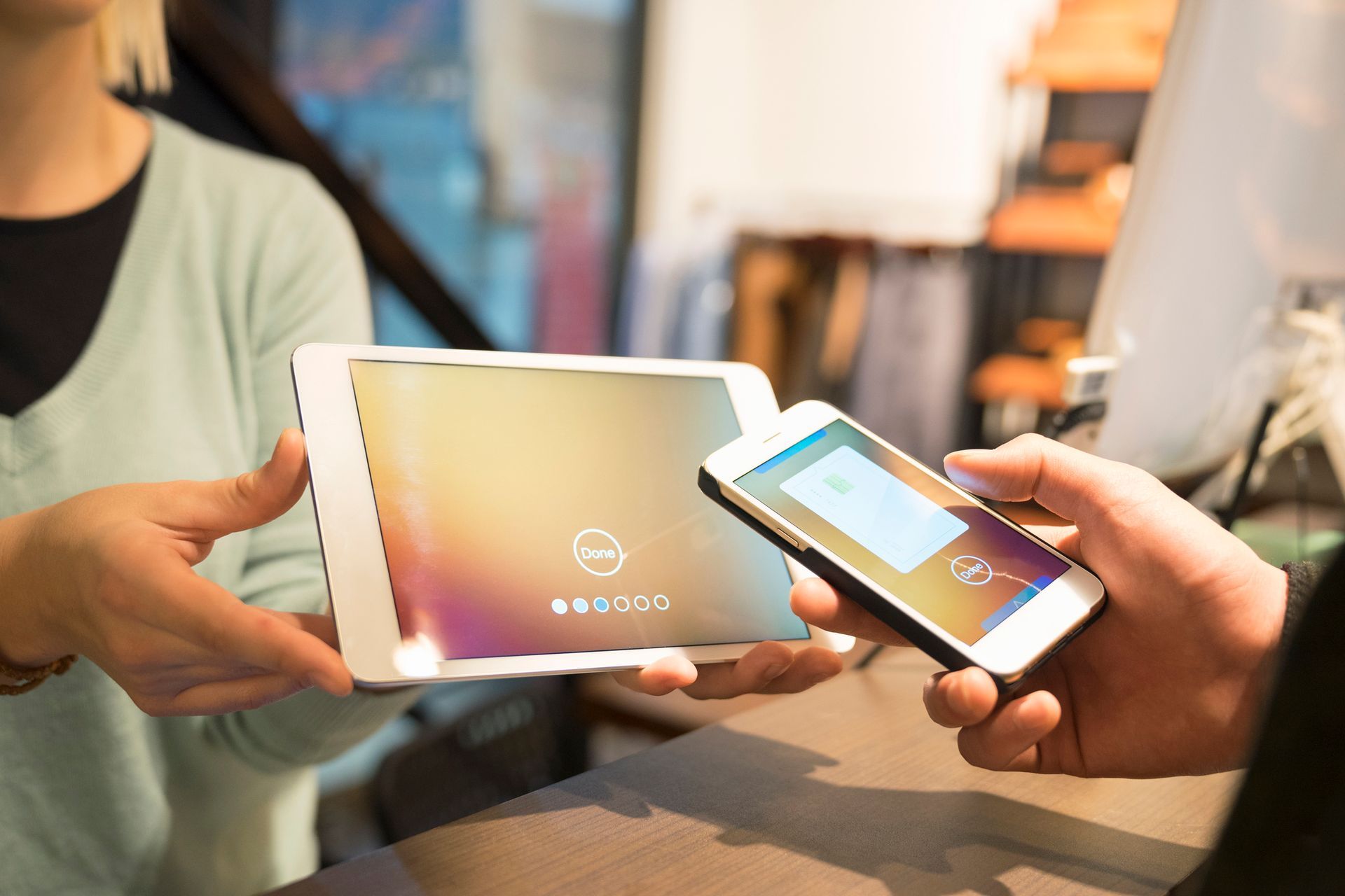 un uomo tiene in mano un tablet e un cellulare con l' icona della carta di credito sullo schermo