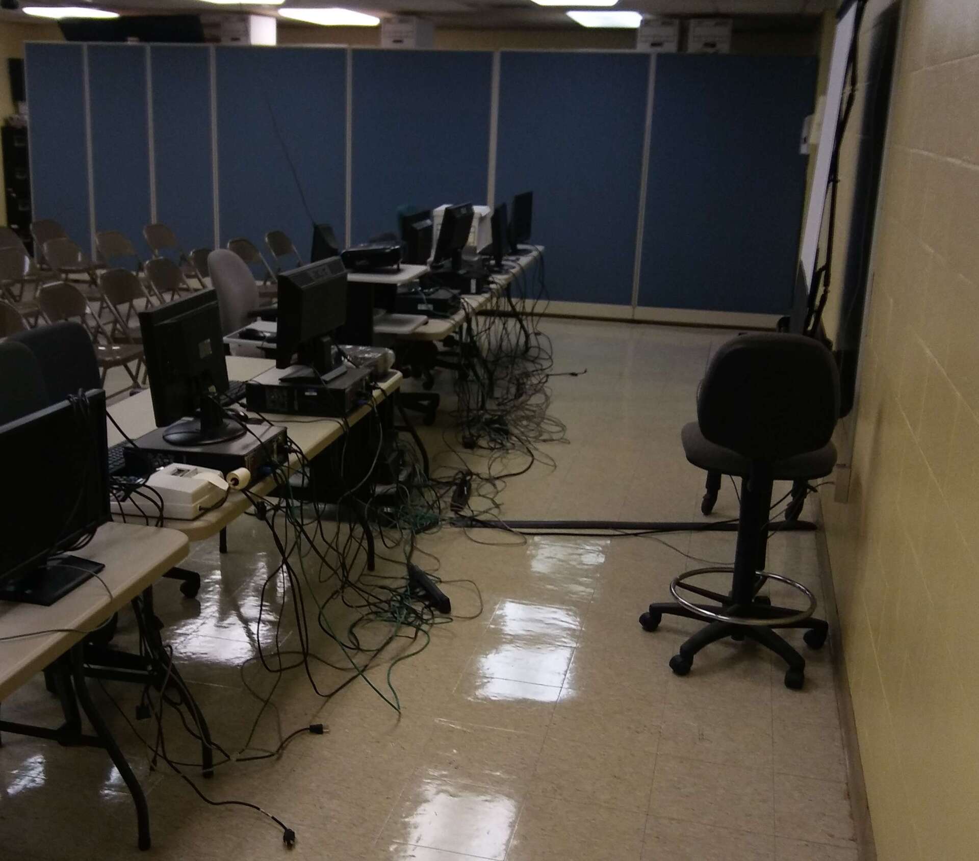 A room with a lot of computers on tables and chairs