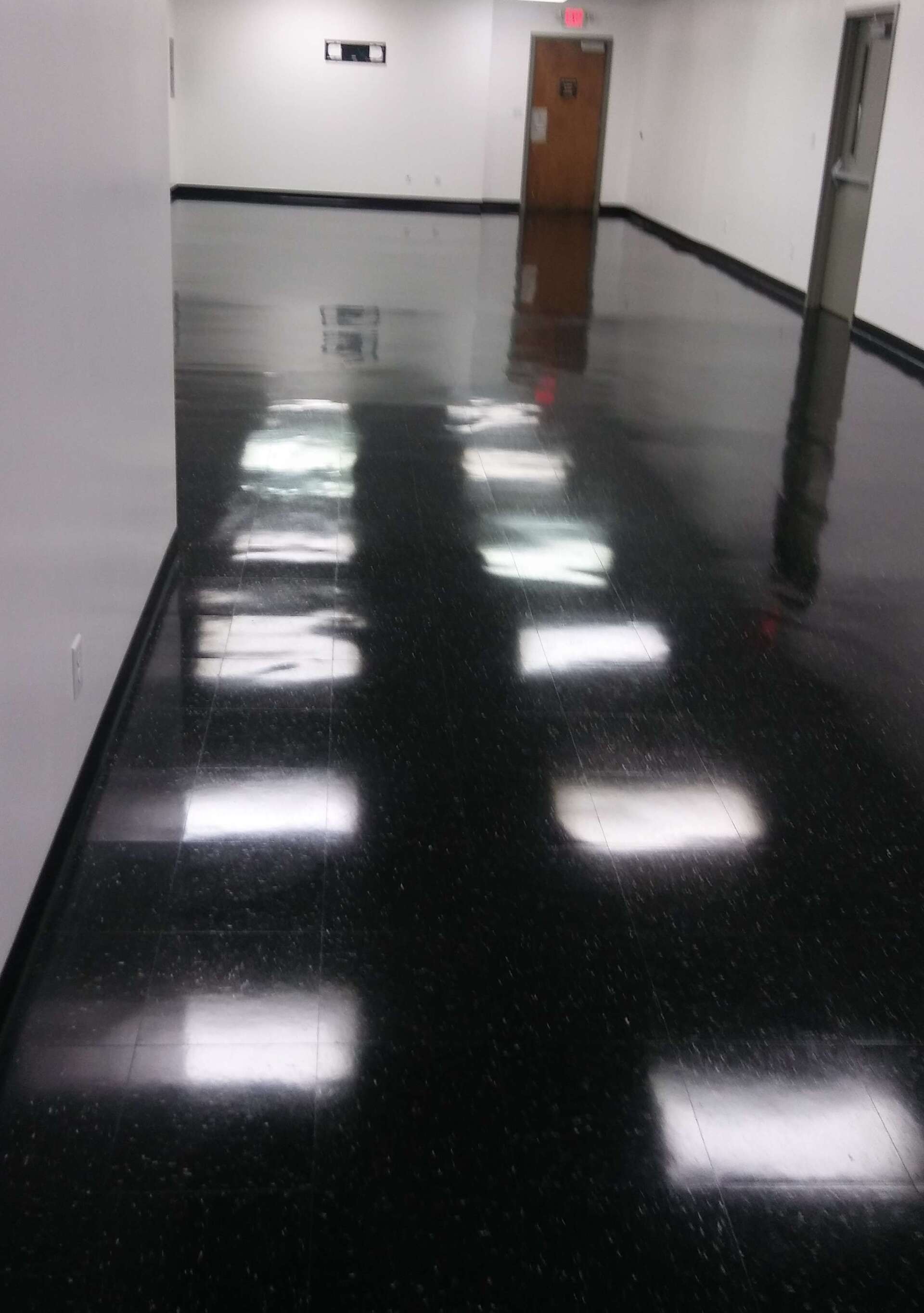 A hallway with a black floor and white walls