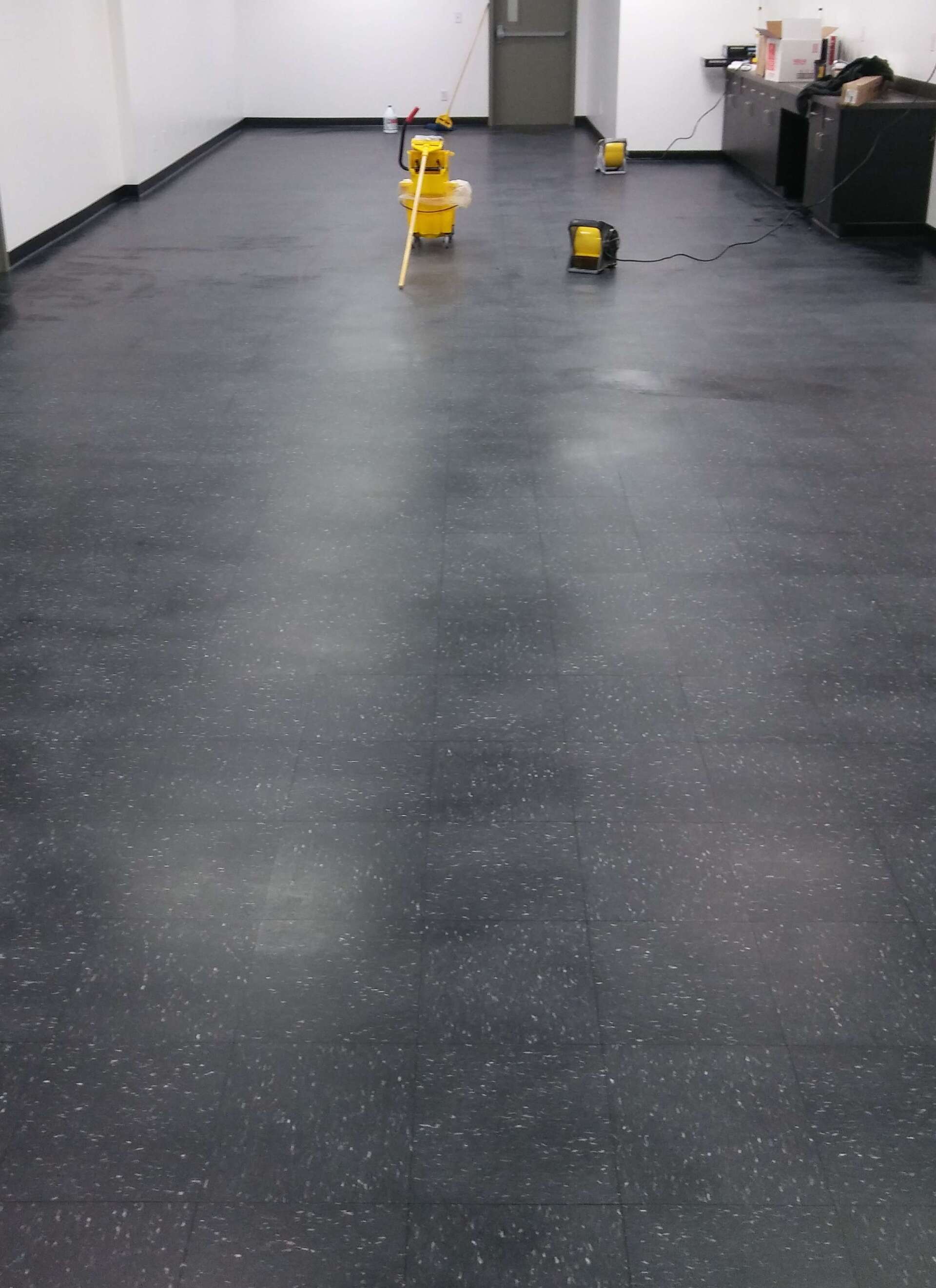 A black floor with a yellow mop on it