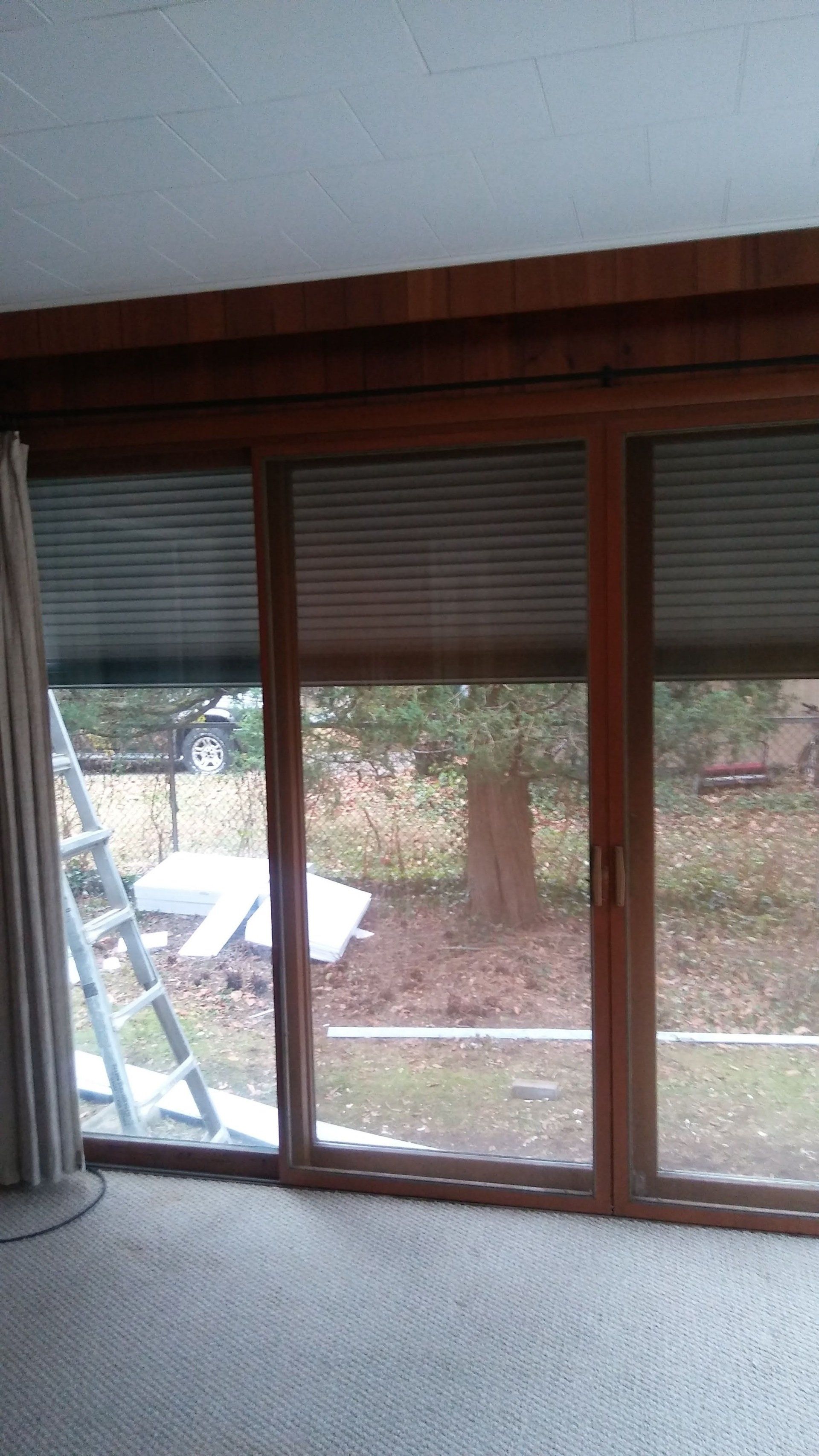 A room with a large window and a ladder in it.