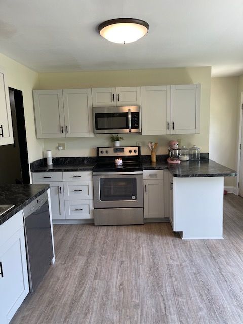 A kitchen with stainless steel appliances and white cabinets