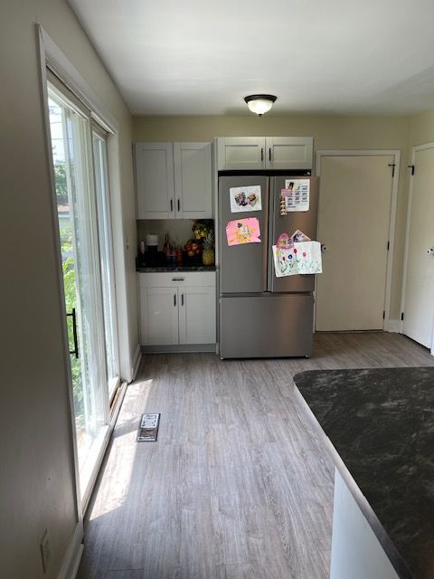 A kitchen with a stainless steel refrigerator and a sliding glass door.