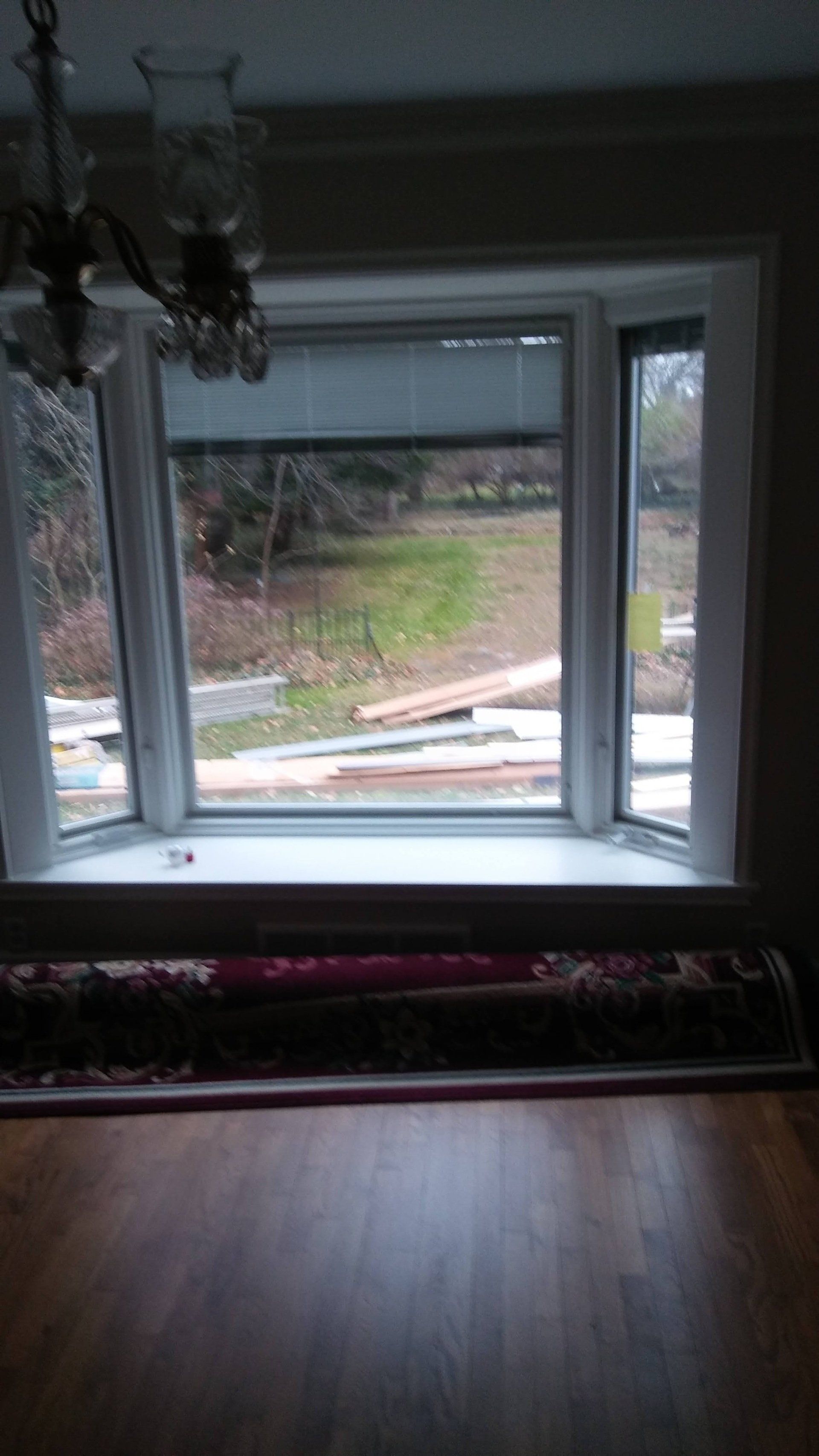 A room with a large window and a wooden floor.