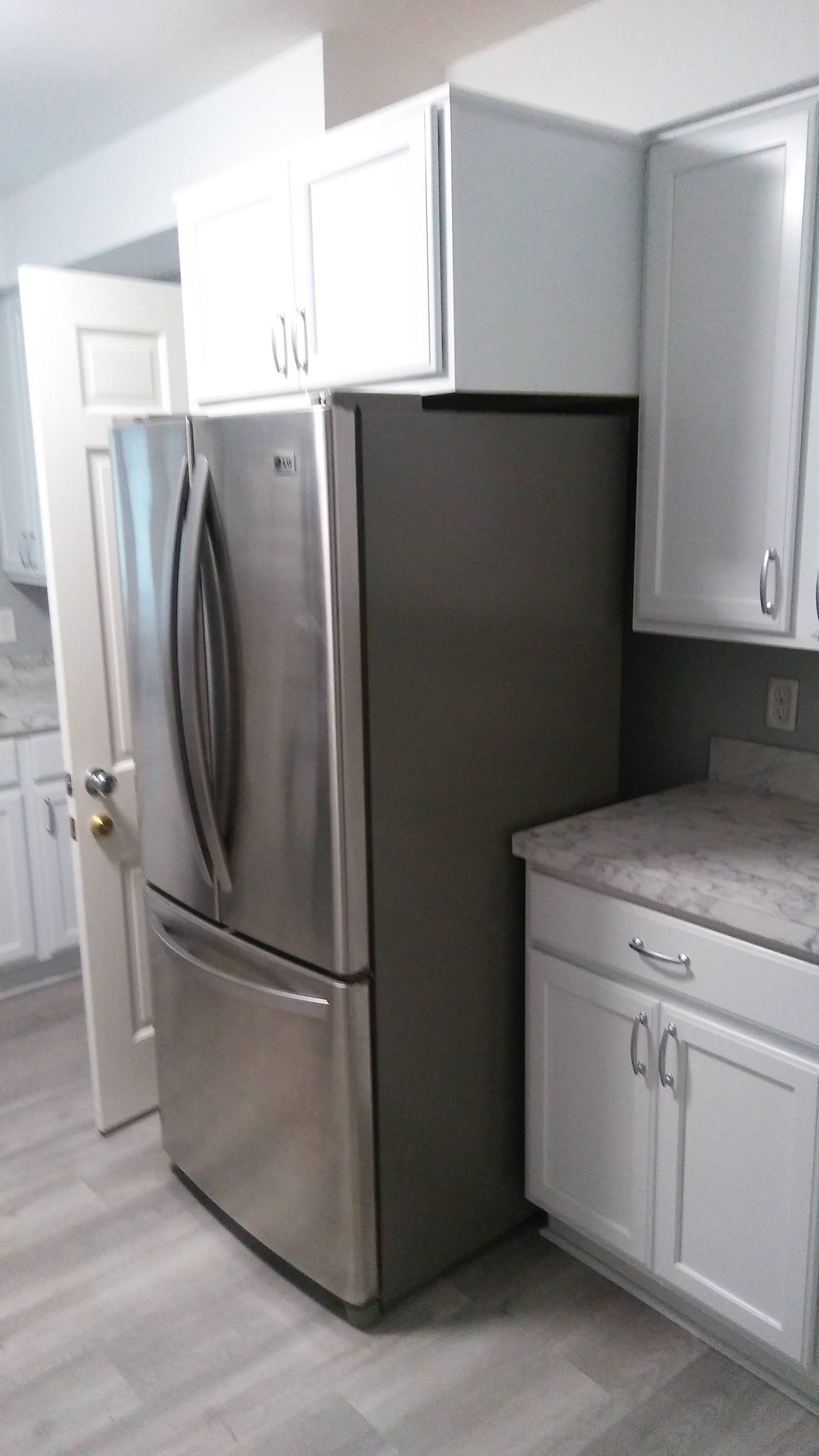 A stainless steel refrigerator is sitting in a kitchen next to a counter.